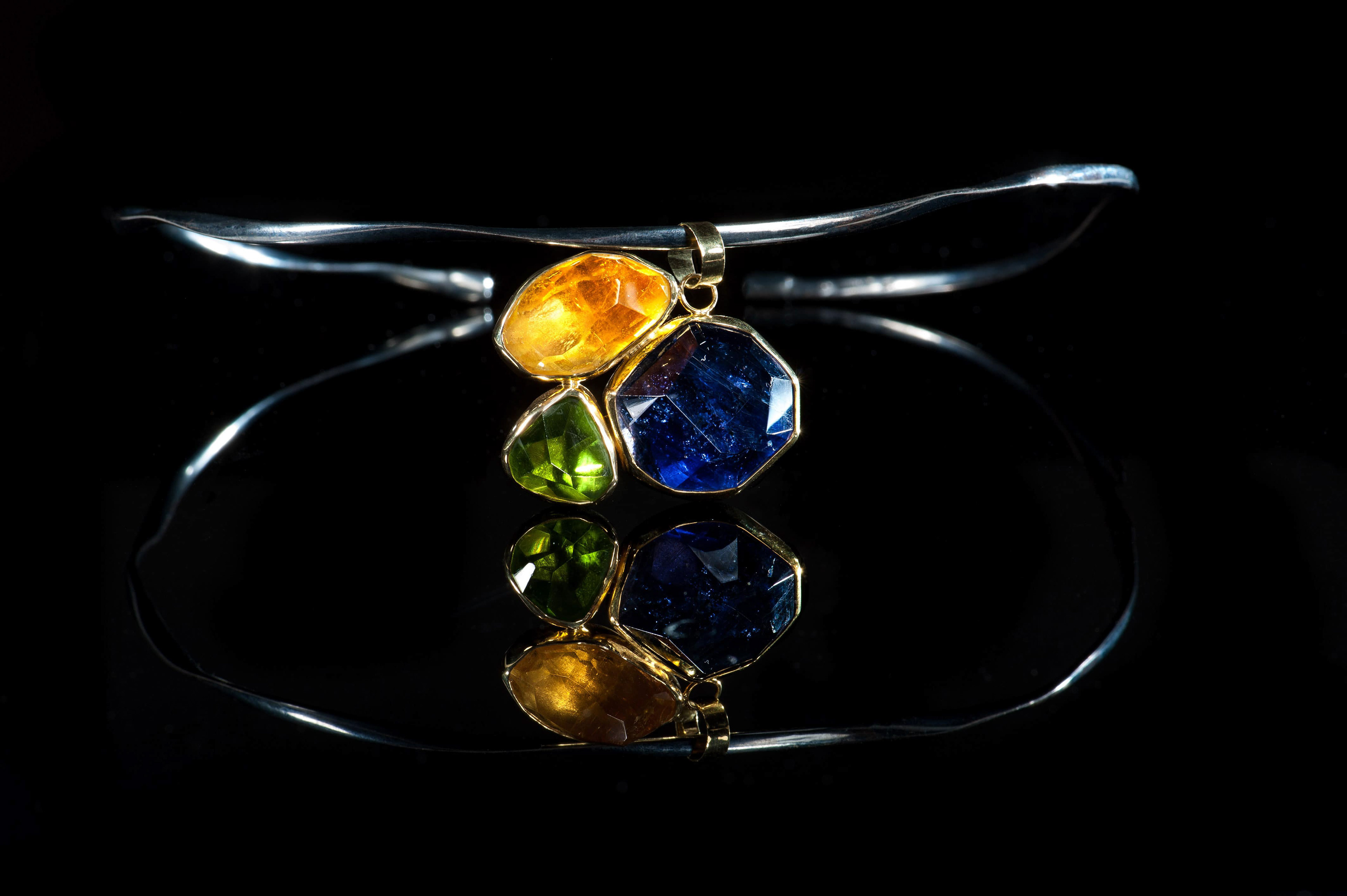 Margoni jewellery: μενταγιόν χρυσό σε ακανόνιστο σχέδιο με τρείς διαφορετικούς ημιπολύτιμους λίθους σε ασημένιο κολιέ σε μαύρο φόντο