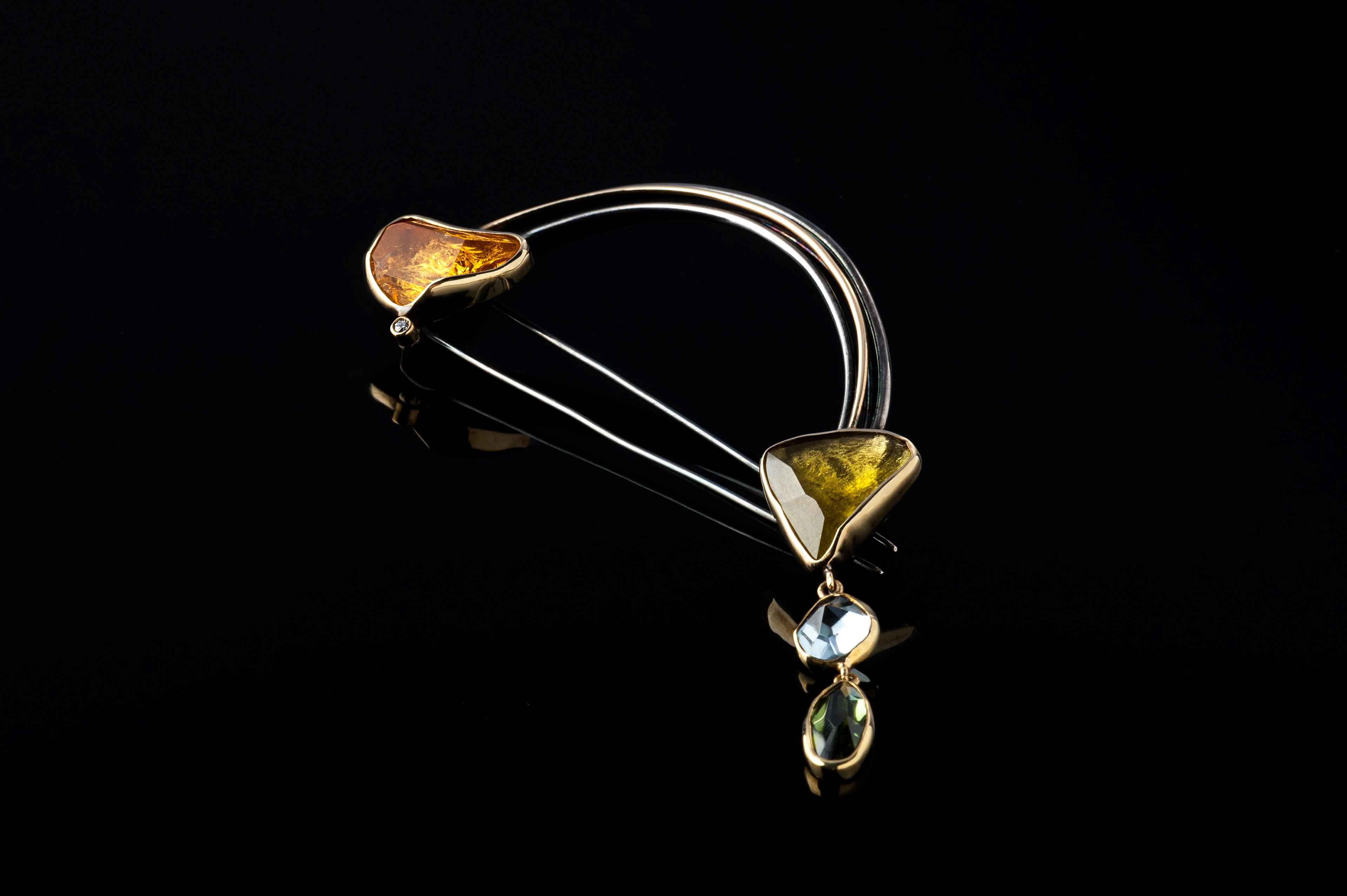 "Margoni jewellery: καρφίτσα ασημένια με κίτρινη ημιπολύτιμη πέτρα σε μαύρο φόντο"