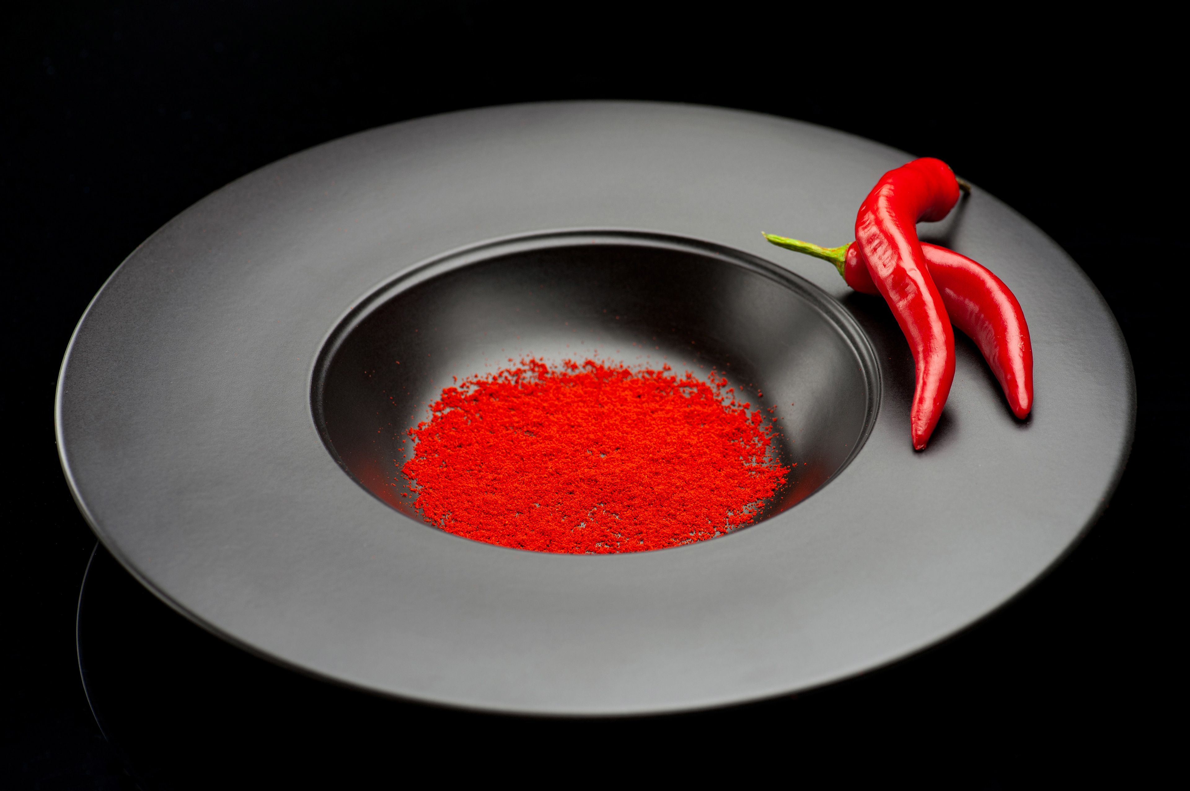 Σύνθεση πιάτου με μπαχαρικά chilli σε σκόνη και πιπεριές σε clean minimal background