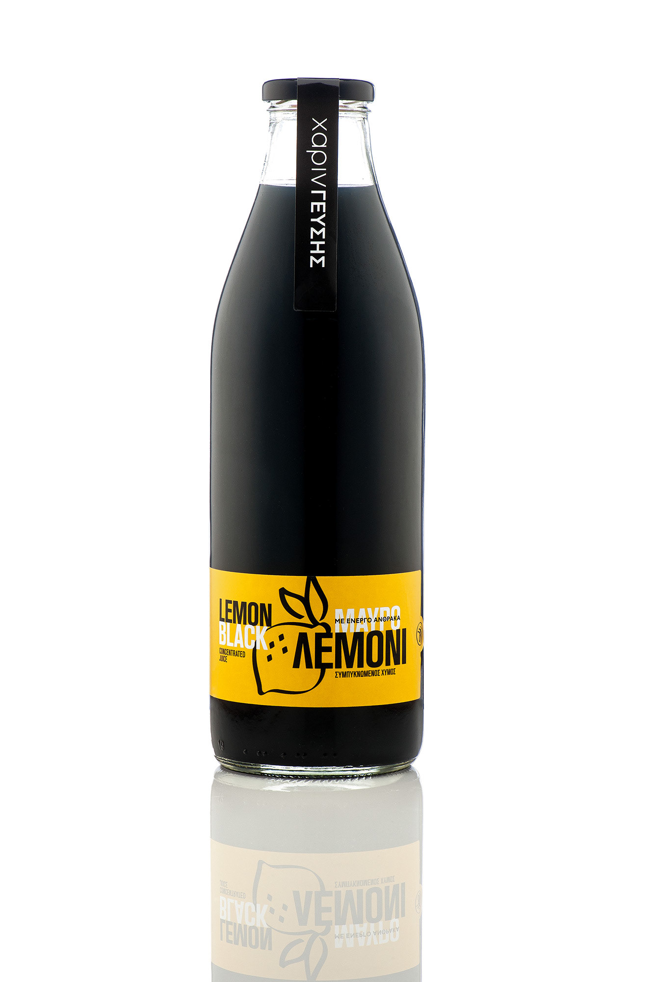 Studio product shot, γυάλινο μπουκάλι με μαύρη λεμονάδα και κίτρινη ετικέτα «Μαύρο Λεμόνι με Ενεργό Άνθρακα» σε λευκό υπόβαθρο, που καθρεφτίζεται στη βάση του.  ,   Commercial product photography of a premium  "Lemon Black" juice bottle on a pure white background, showcasing crisp reflections and clean packaging design.  