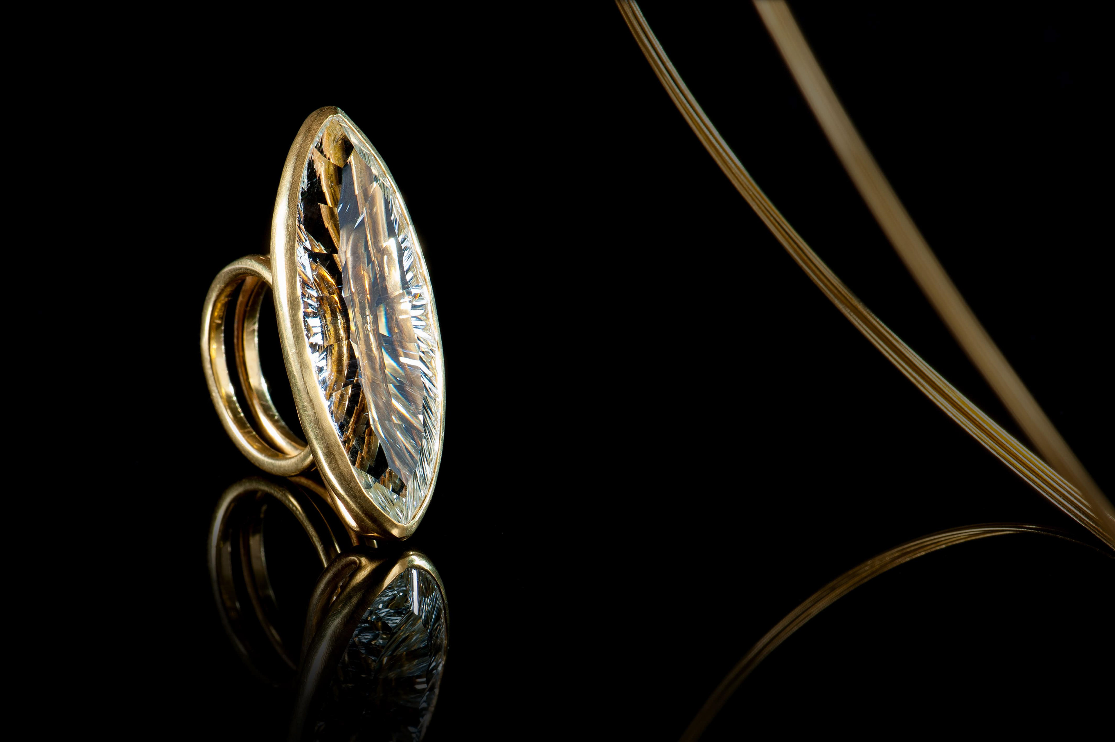 Margoni jewellery: δαχτυλίδι με διάφανη ημιπολύτιμη πέτρα και μίνιμαλ χρυσός σε μαύρο φόντο