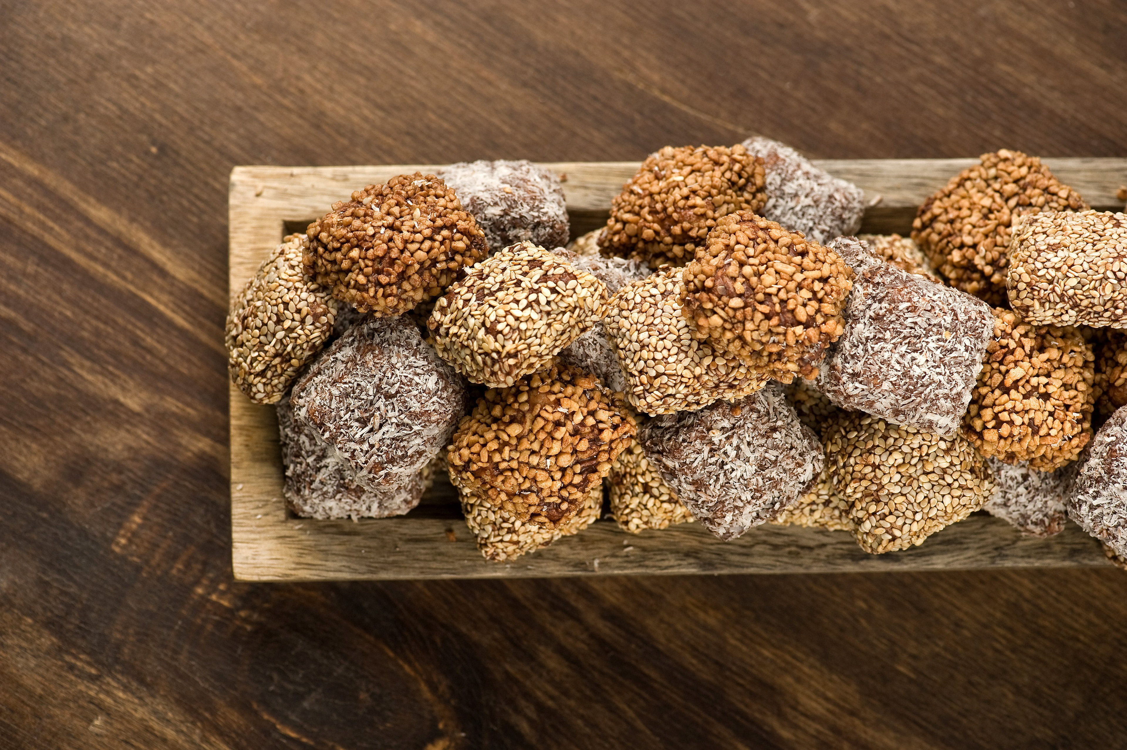 voula gkoti photography praline filled bites .peanut butter and coconut on a wooden tray for laurence galerie de chocolat
