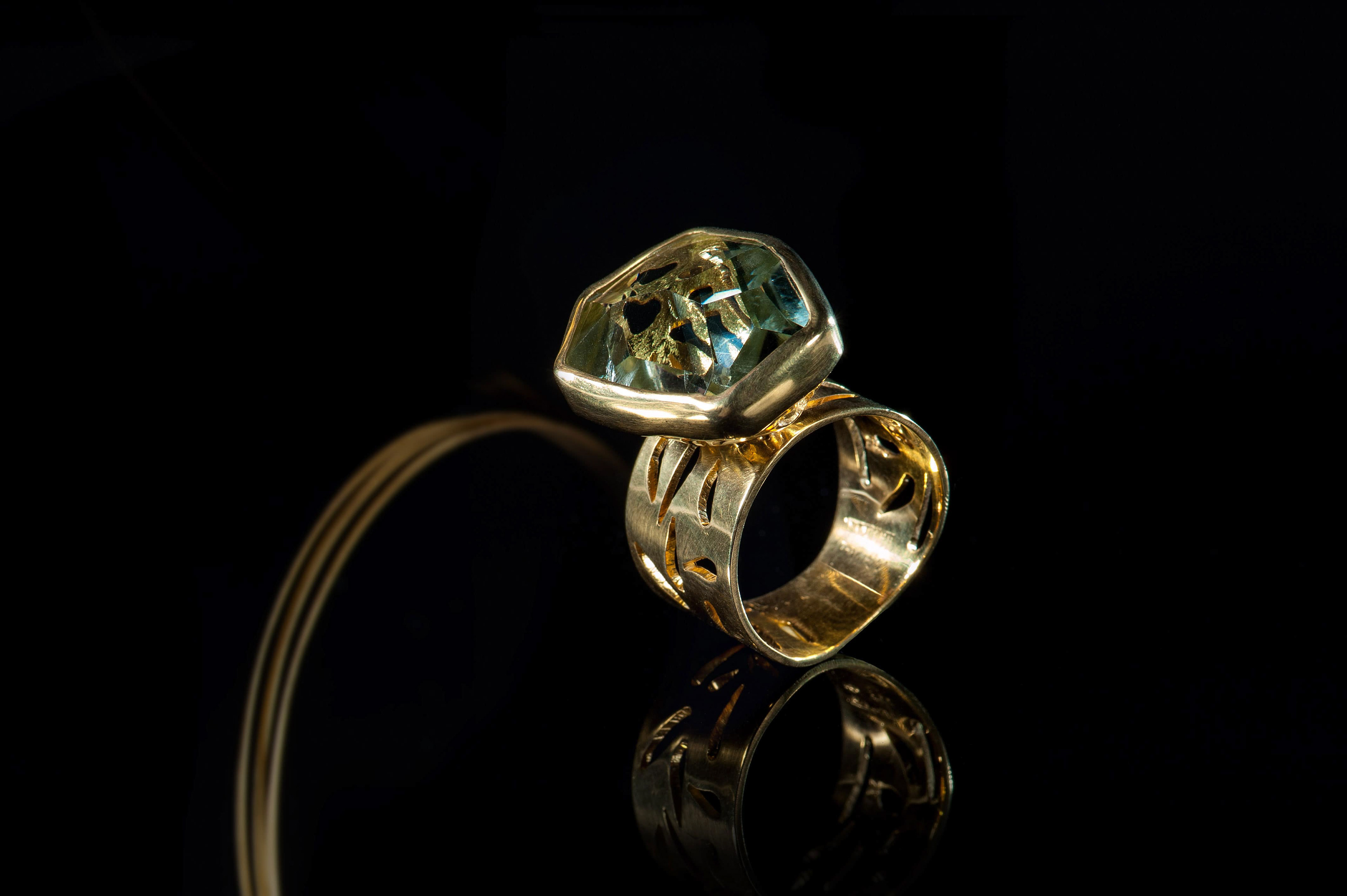 Margoni jewellery: χρυσό χειροποίητο δαχτυλίδι, με ανάγλυφη λεπτομέρεια σε μαύρο background
