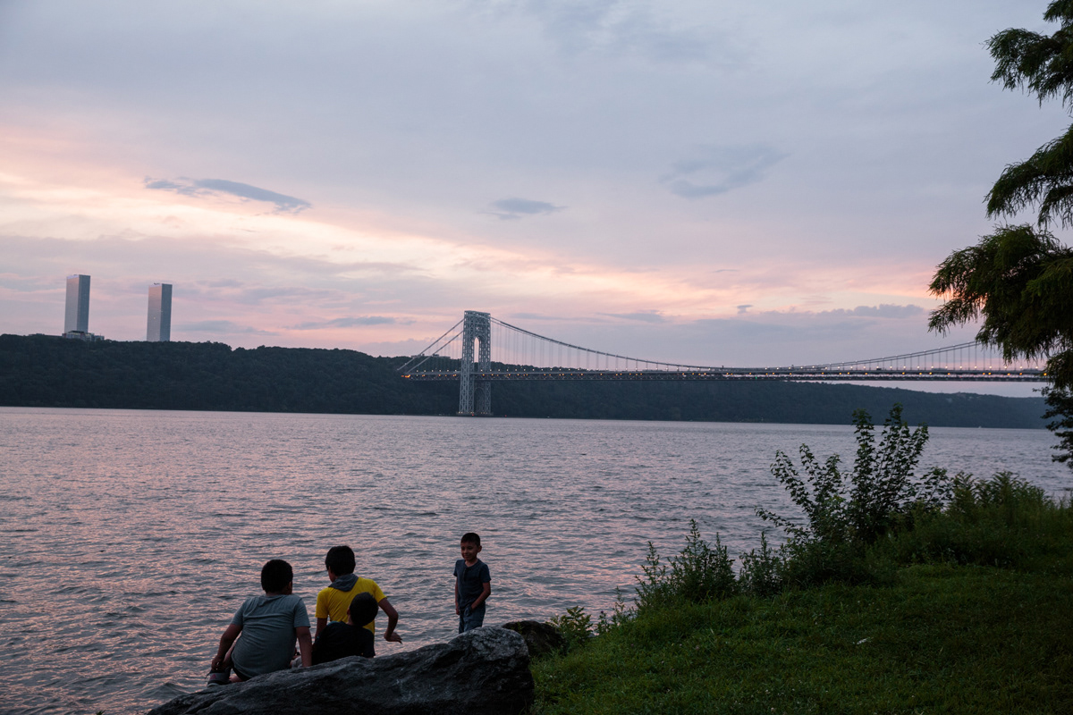 Kids play along the riverfront at the Hudson River Greenway on a Sunday evening.