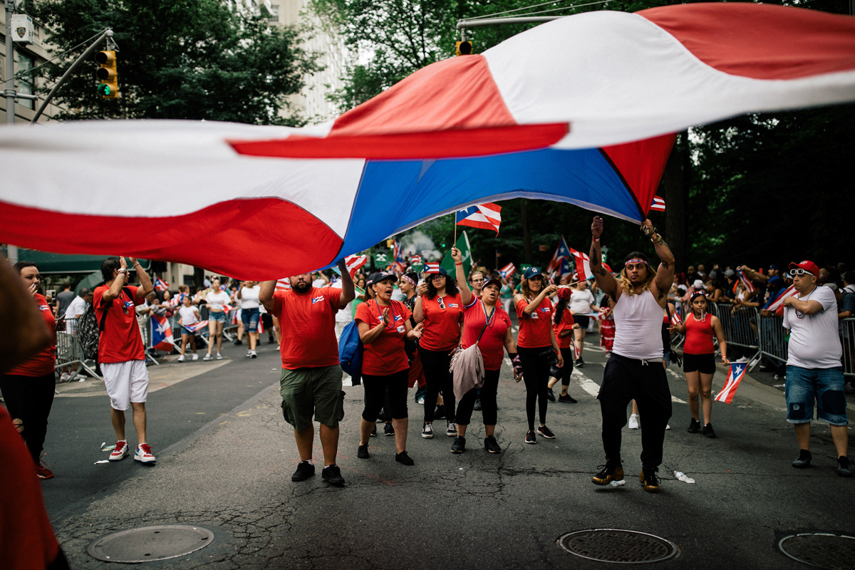 Marchers walk down Fifth Avenue waving Puerto Rican flags and chanting to the crowds.