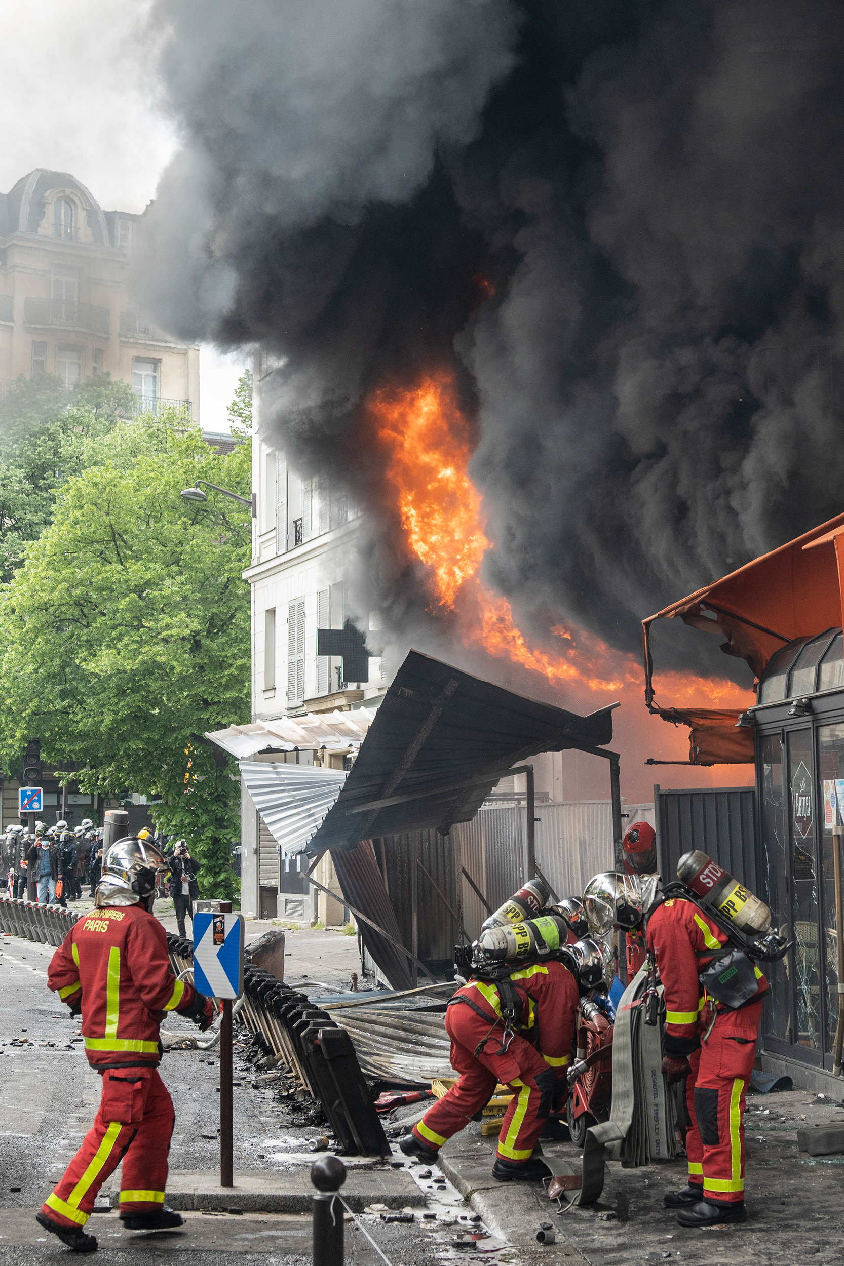 Feuerwehrkräfte löschen einen Brand am Rande des Place de la Nation.