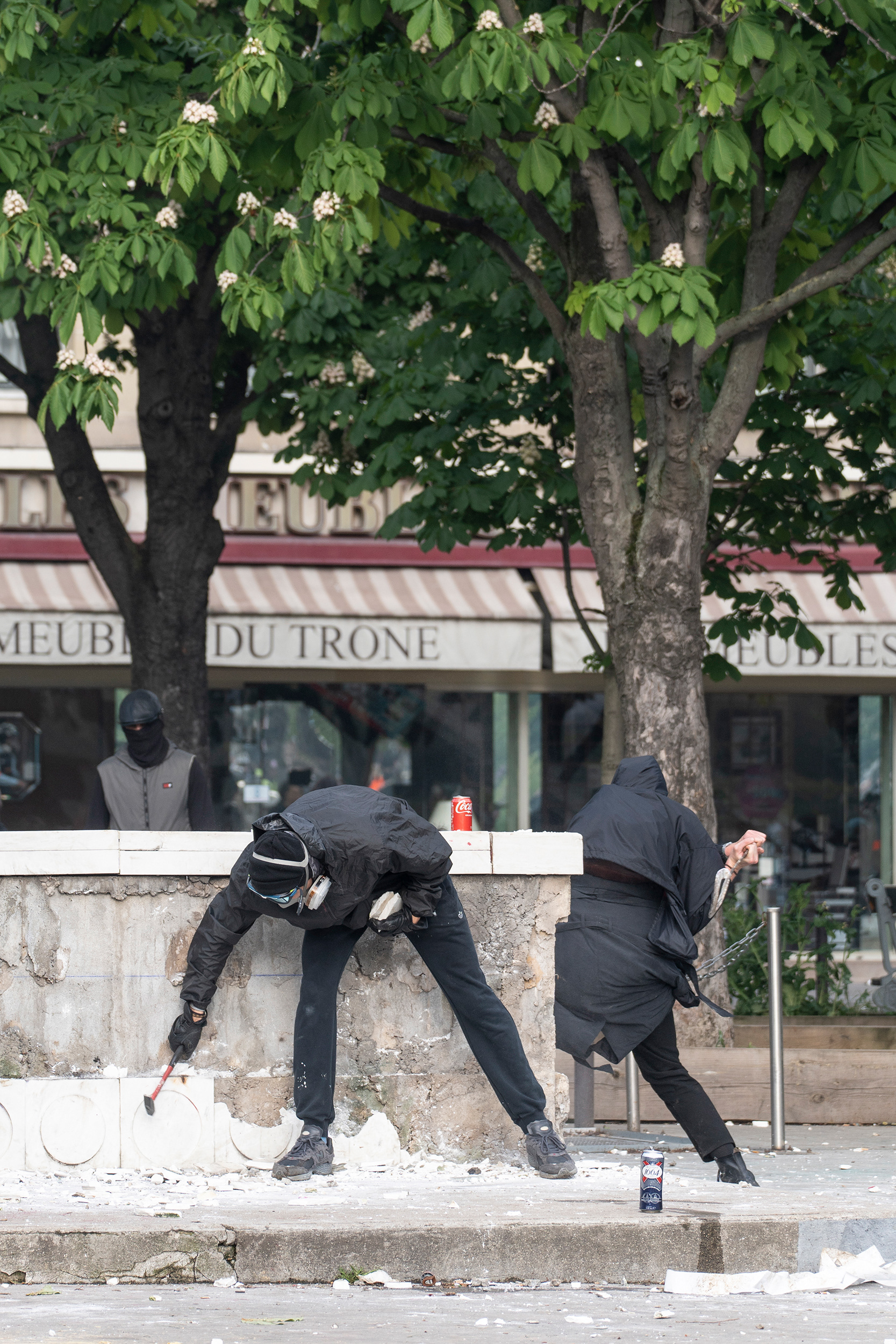 Demonstrant*innen hauen Steine aus der Wand um sie als Wurfgeschosse zu verwenden.