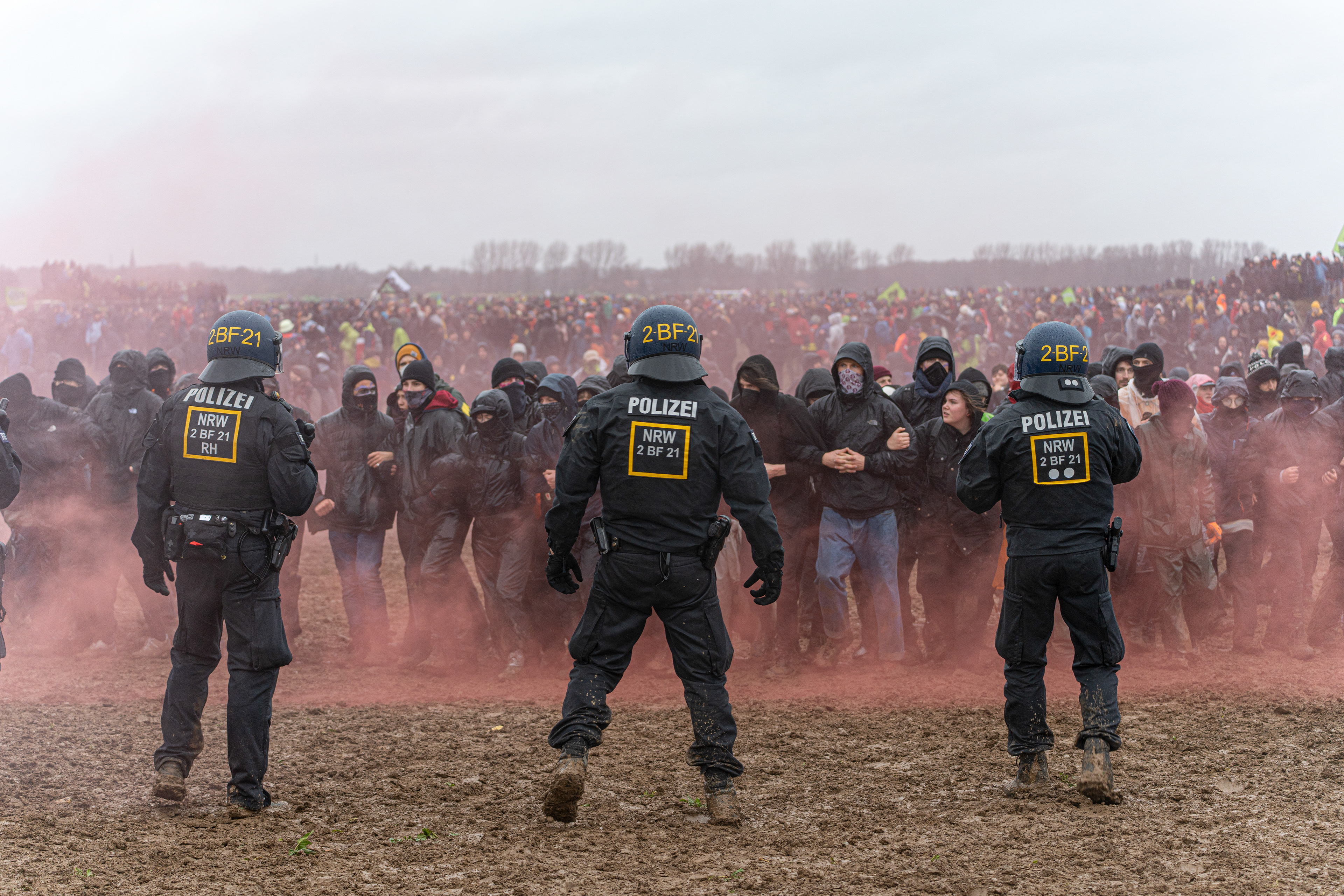 EIne Kette aus Demonstrant*innen laufen auf die Polizist*innen zu
