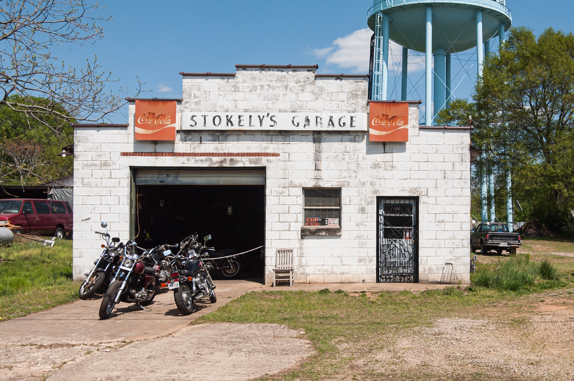 Stokely’s Garage with motorcycles and the Crawford water tower in the background, photographed in April 2014