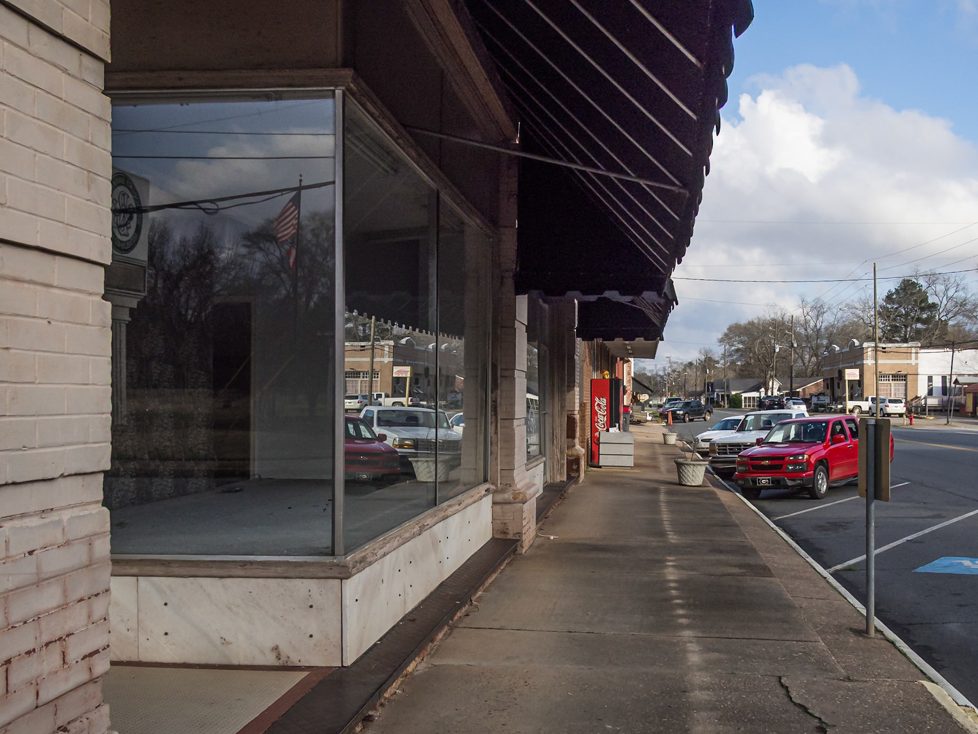 Storefronts and sidewalk along a commercial block in downtown Woodbury, Georgia, in December 2015