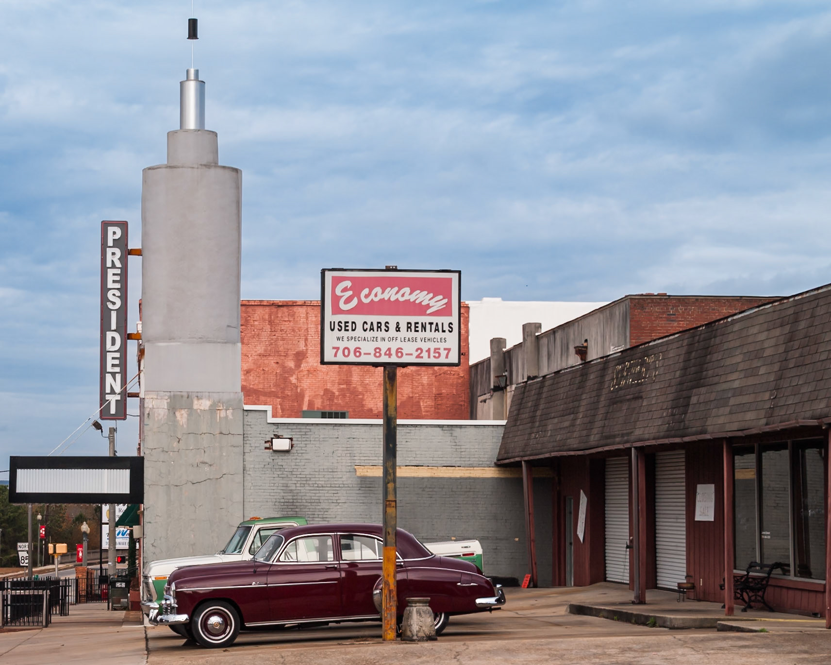 The President Theatre, Economy Used Cars sign, and a vintage automobile in downtown Manchester, Georgia, photographed in November 2013