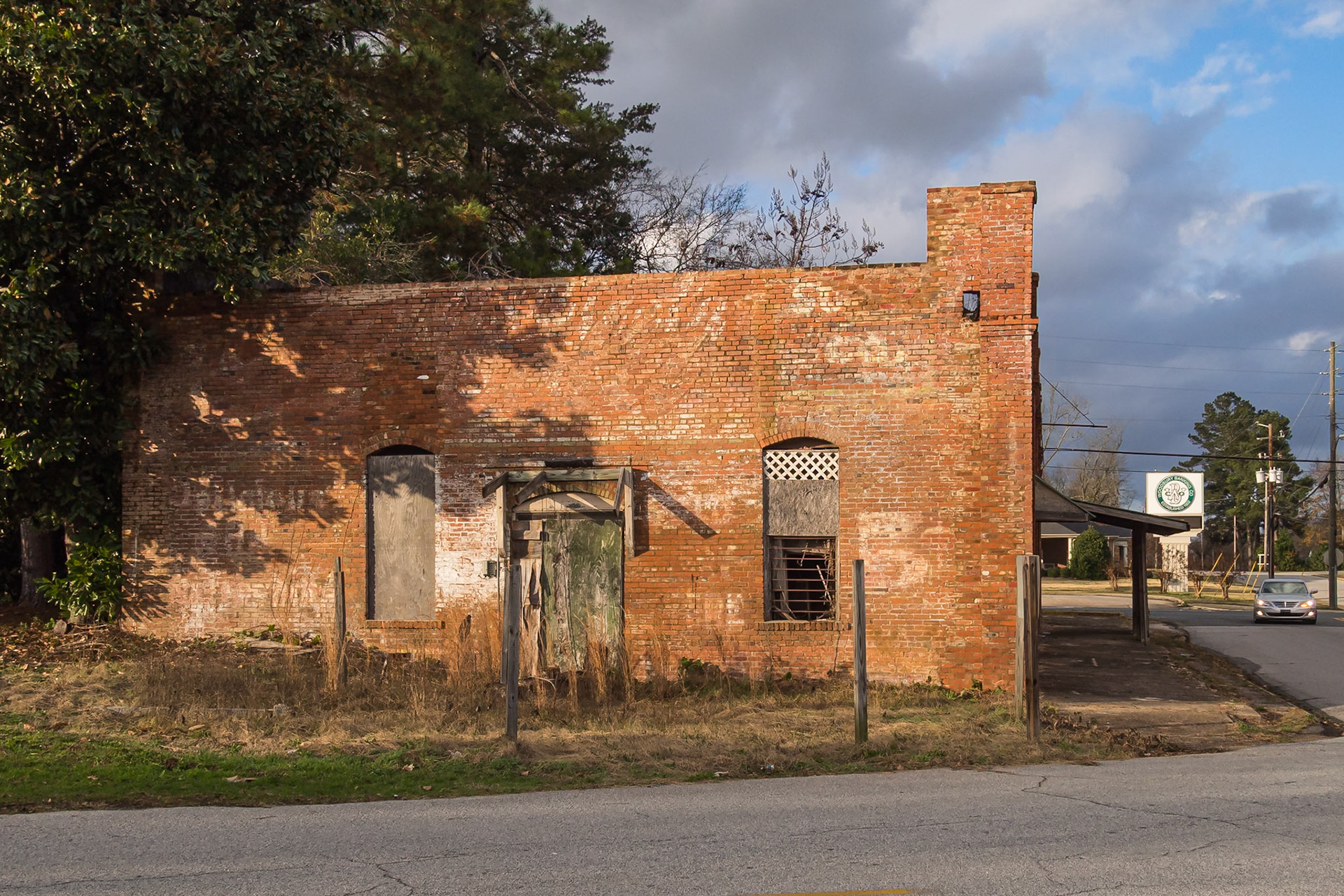 A deteriorating brick building with faded wall lettering in Woodbury, Georgia, in December 2015