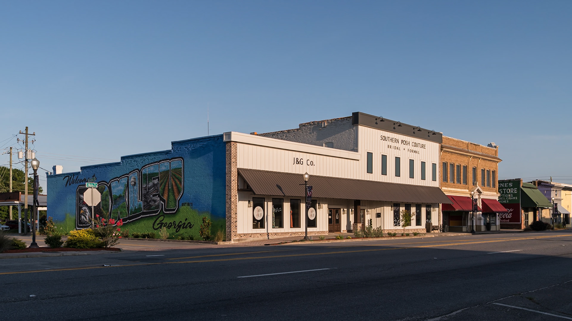 The Welcome to Baxley mural and adjoining commercial buildings along a downtown block, in June 2024