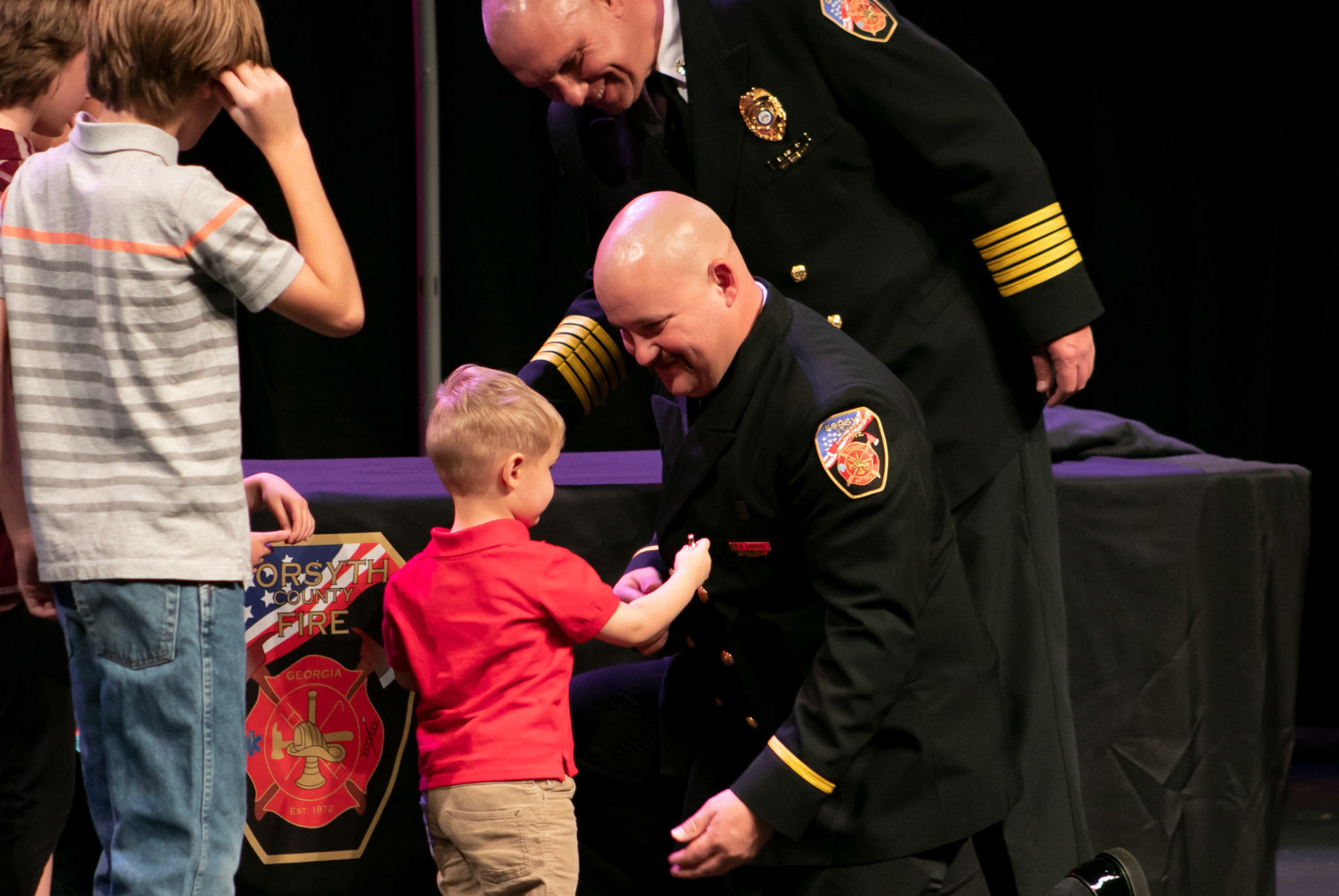 Son pins father's new badge after receiving promotion