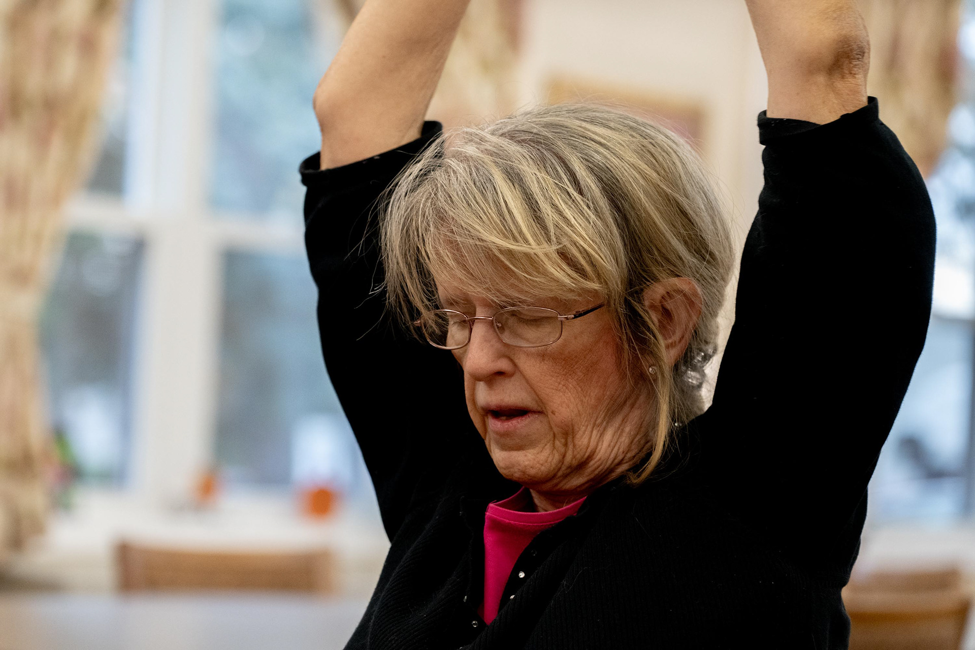 Mary exhales as she holds a resistance band during one of the exercises in the “Tone It Up” class on Tuesday, Nov. 4, 2025, in Syracuse, N.Y. Mary is also one of the resident living in the same building as Barb.