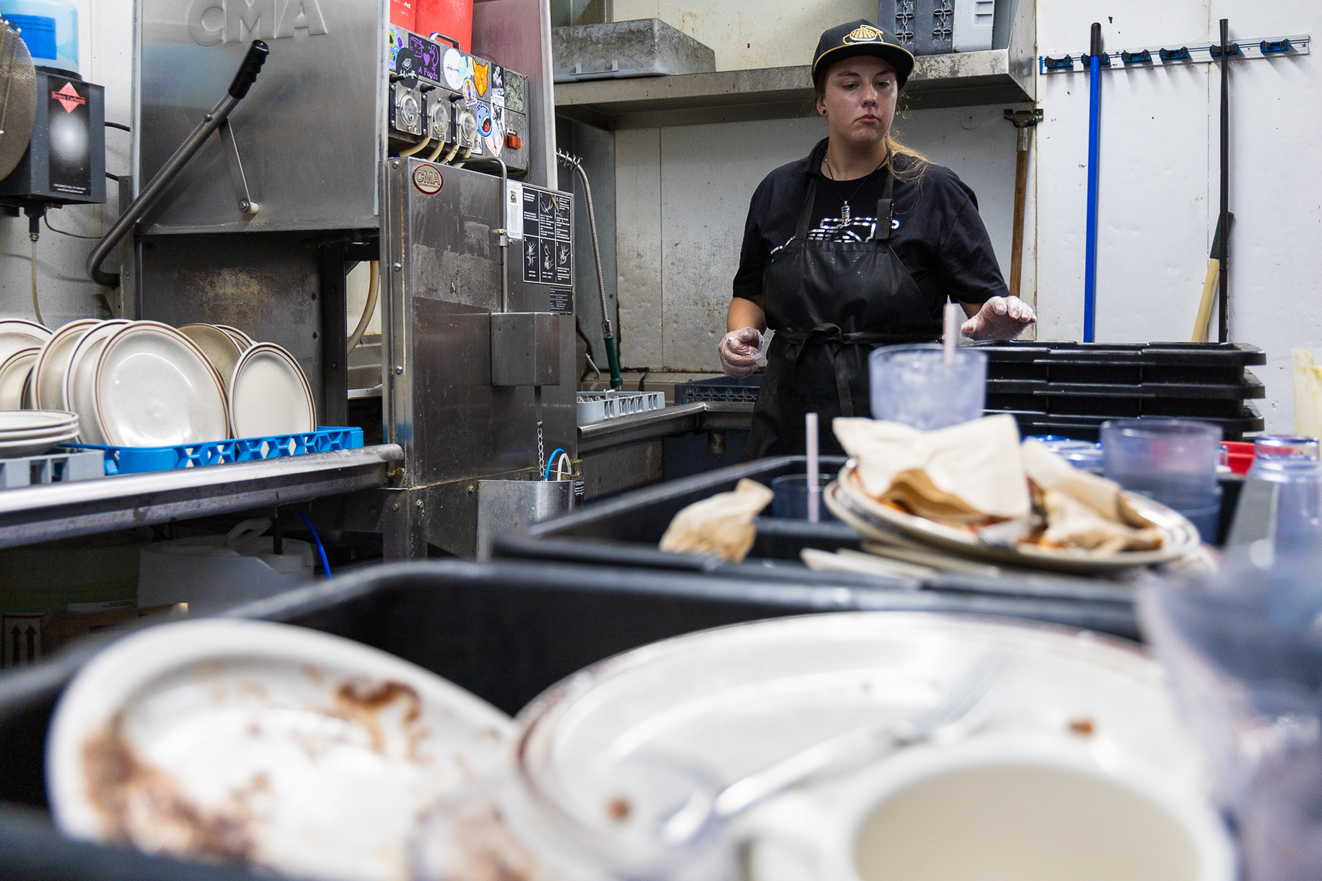 Funk ’n Waffles line cook washes the dirty dishes as the orders keep coming for the downtown Syracuse, NY music venue’s late night customers. She works the labor-intensive job until around 2am several nights a week, doing work that is often unseen by residents with more traditional schedules.