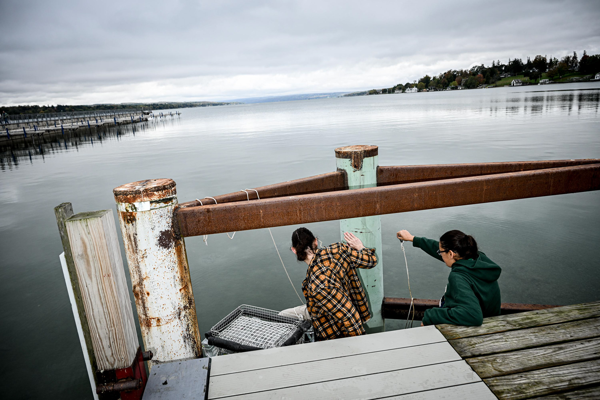 Ph.D. student Zac Triumph and postdoctoral associate Dr. Dominique Derminio deploy a rack of nutrient bottles in Skaneateles Lake on Tuesday, Oct. 14, 2025, in Skaneateles, N.Y. The experiment examines how various nutrient conditions affect algae growth. 