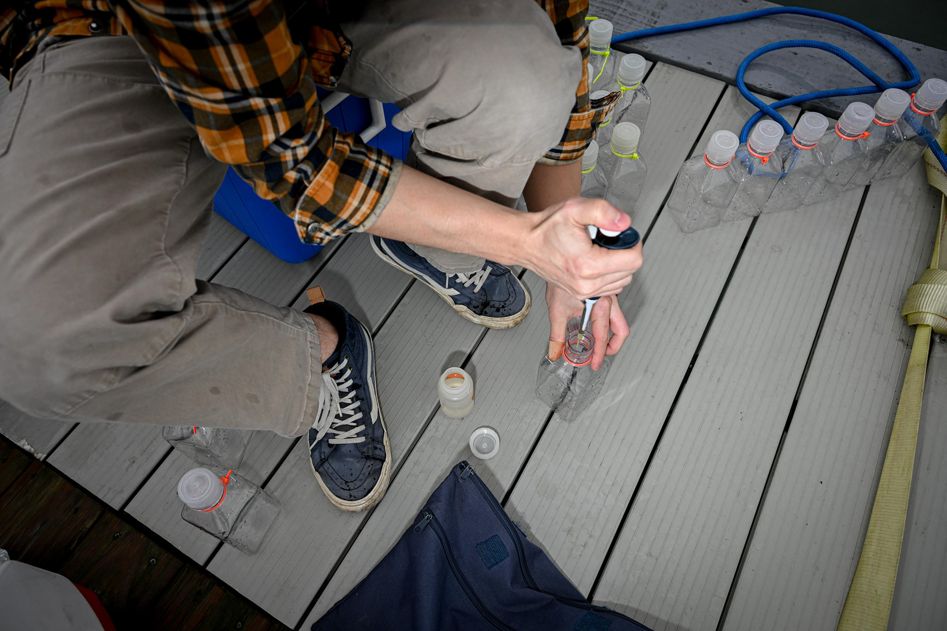 Zac Triumph collects water from Skaneateles Lake for the nutrient spike experiment, where he and Dr. Derminion add nutrients to bottles filled with water to see if algae can grow better under different nutrient conditions on Tuesday, Oct. 14, 2025, in Skaneatles, NY. 