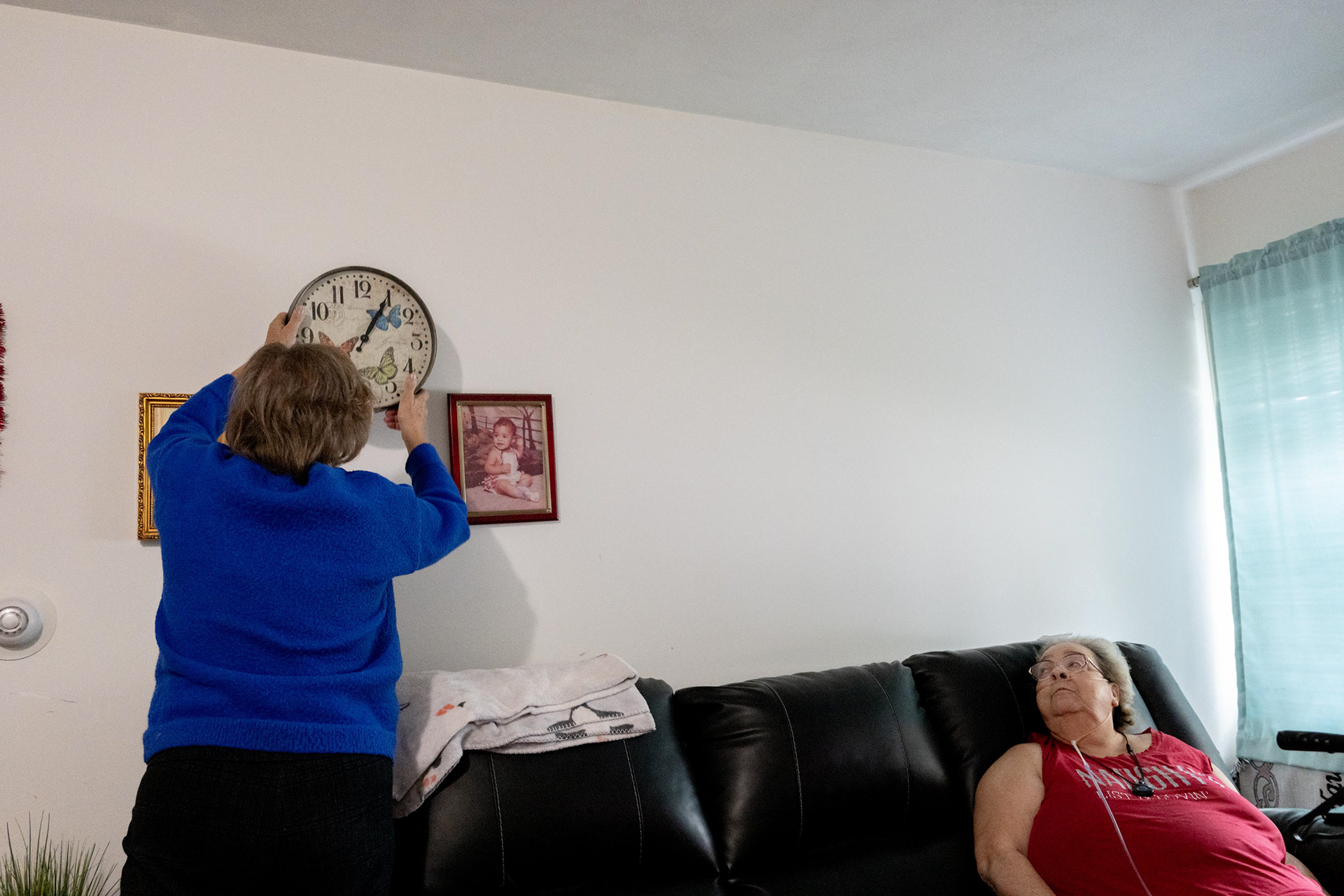Barb changes the clock for Brenda Nichols, on Monday, Nov. 3, 2025, in Syracuse, N.Y. Barbara has been Brenda’s companion for the past two years.