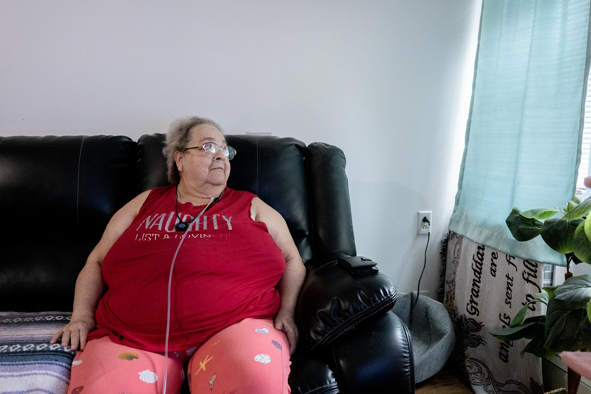 Brenda looks out the window as the rain begins to fall on Monday, Nov. 3, 2025, in Syracuse, N.Y. She says she can’t wait for winter. Brenda has been with Barb for the past two years and says Barb is one of the best things that has ever happened to her.