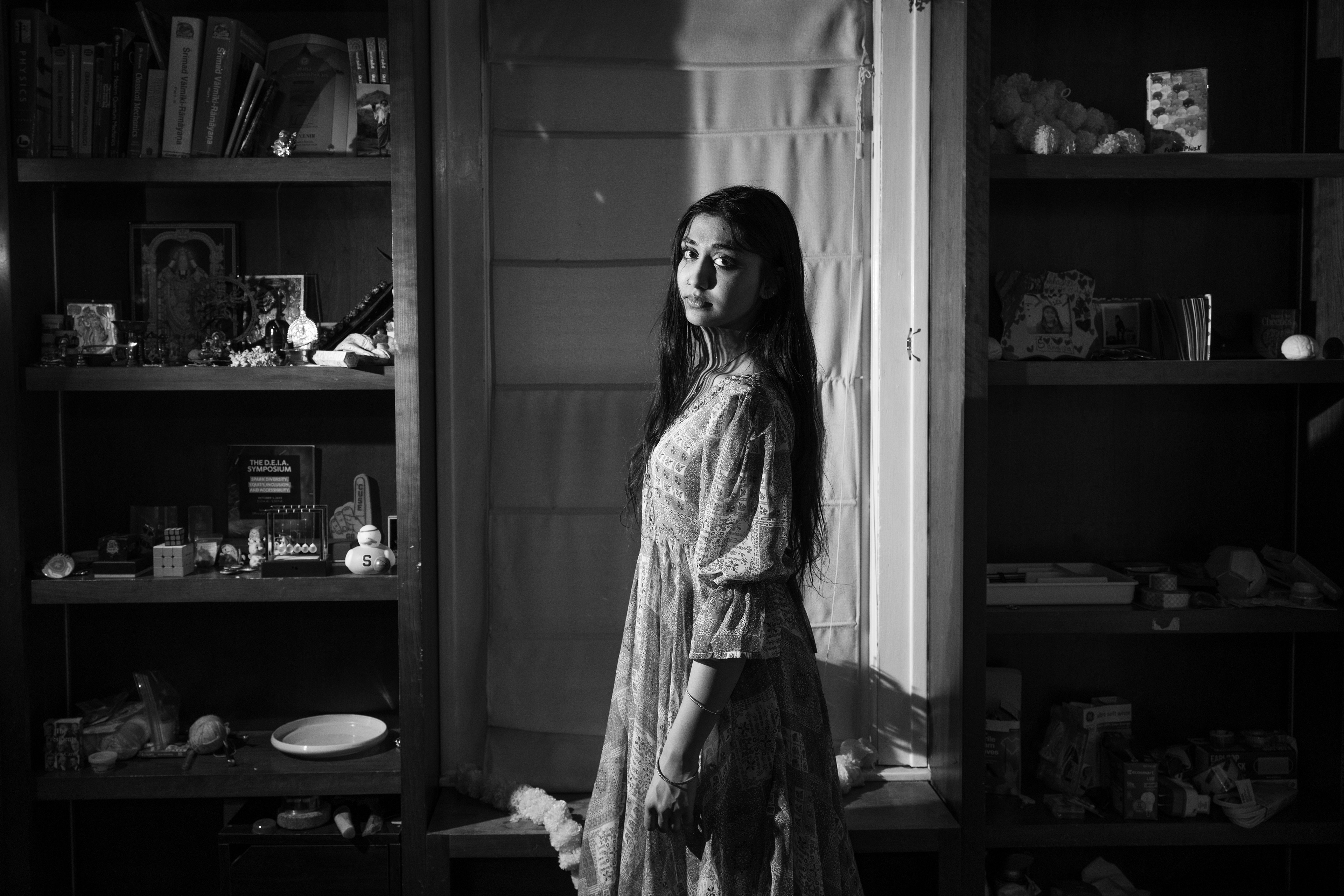 Sahana stands beside a photo of her family, physics textbook and favorite novels in a corner of her room, a space that reflects her sense of peace and identity. The setup captures how she embraces being a dancer, singer and physics major equally.