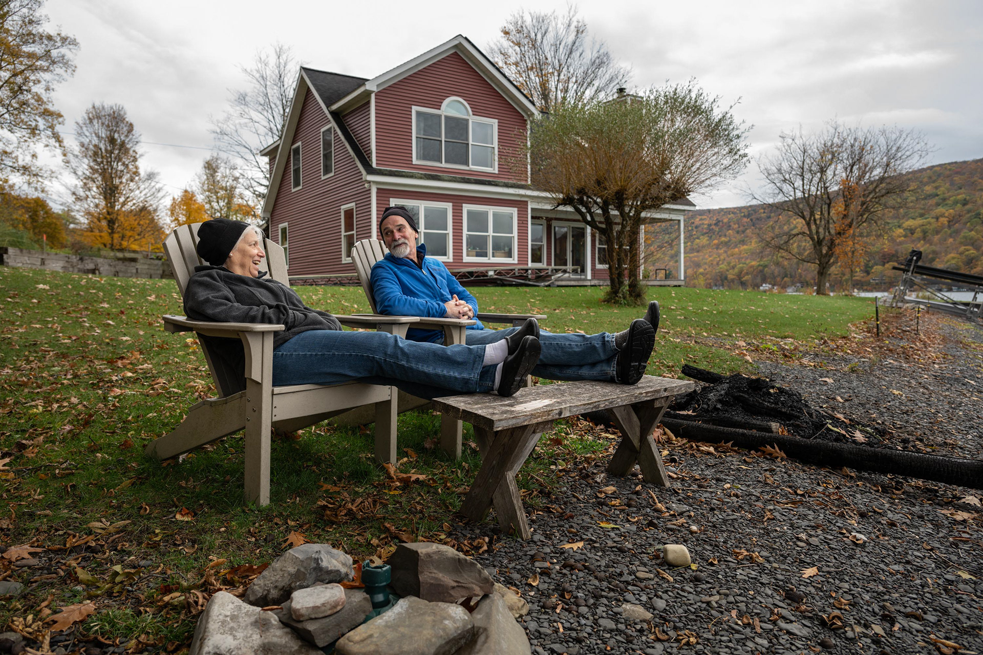 John Hinchcliff and his wife, Robin, sit in their backyard overlooking Skaneateles Lake on Friday, Oct. 24, 2025, in Skaneateles, N.Y. The couple offered their property for researchers to dig two monitoring wells, one near the lake and another near their newly installed septic tank. 
