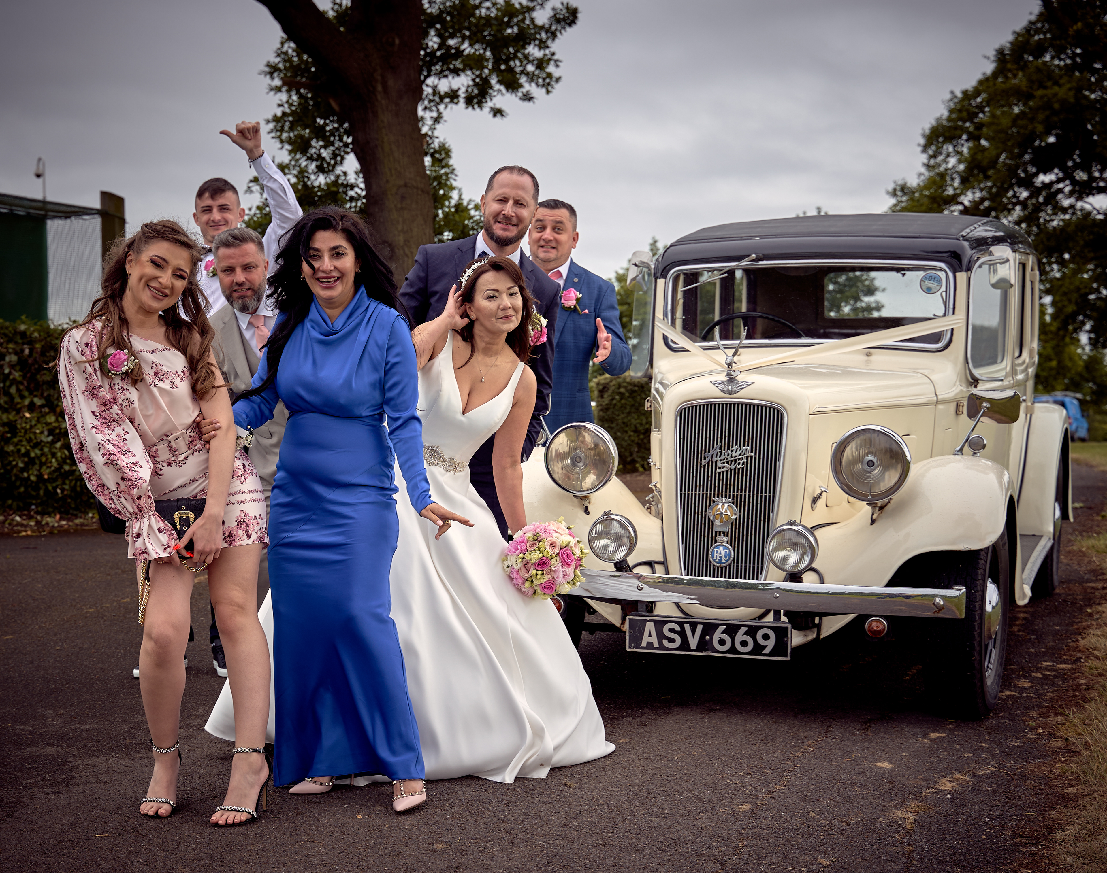 Wedding party next to a classic car