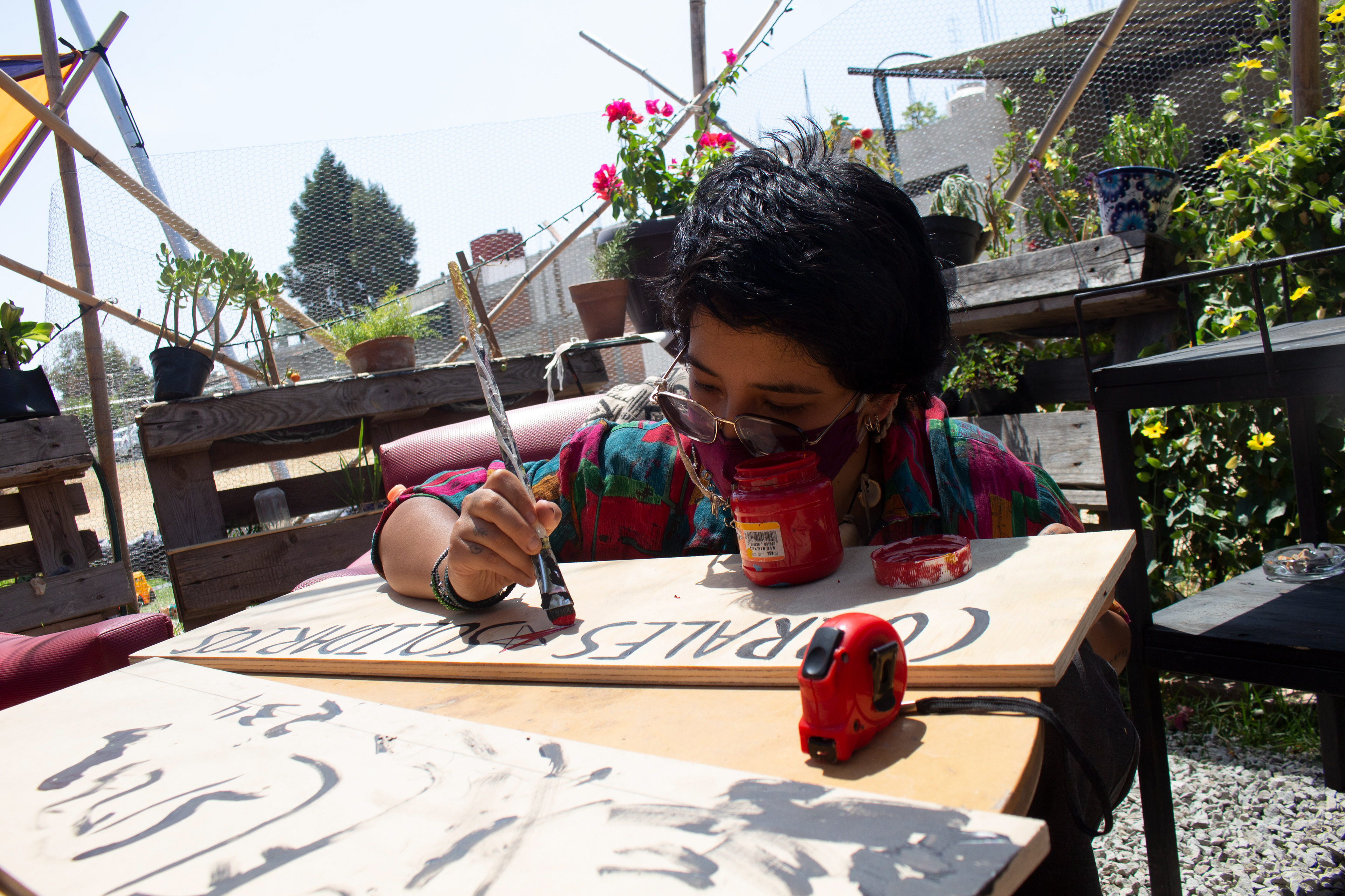 Participante pintando el cartel de "Corrales solidarios" actividad organizada en colaboración con Sr. Click y Proyecto Táctica (Frecuencias Emergentes, 2021).