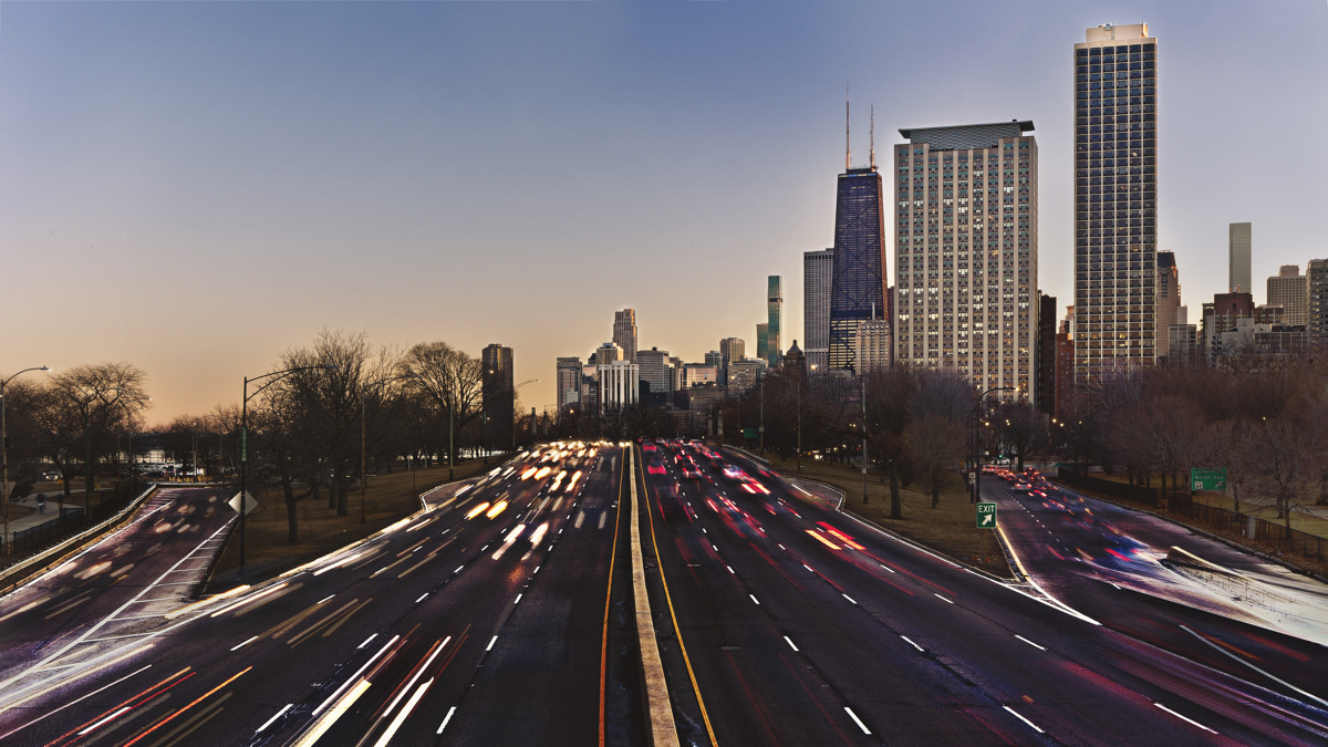 Traffic at night on Lake Shore Drive with Chicago Skyline in the background.