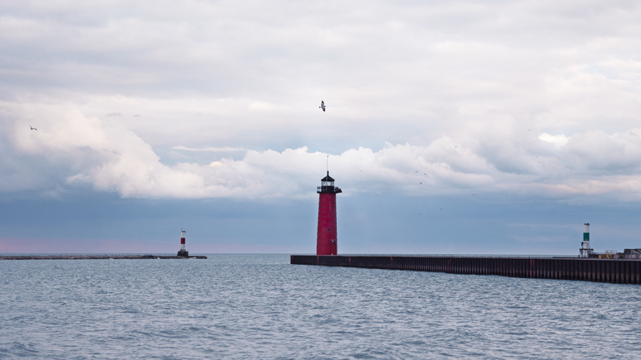 Bird flying over  the iconic red Kenosha Lighthouse on Simmons Island in Kenosha Wisconsin.