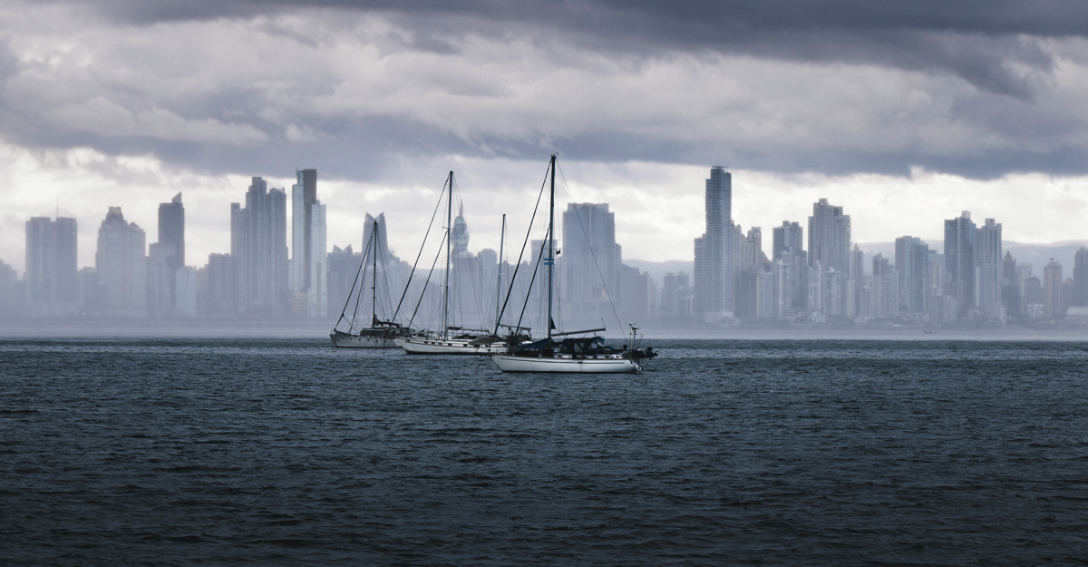 Fine art photo of three boats sailing in front on the Panama City skyline during a storm
