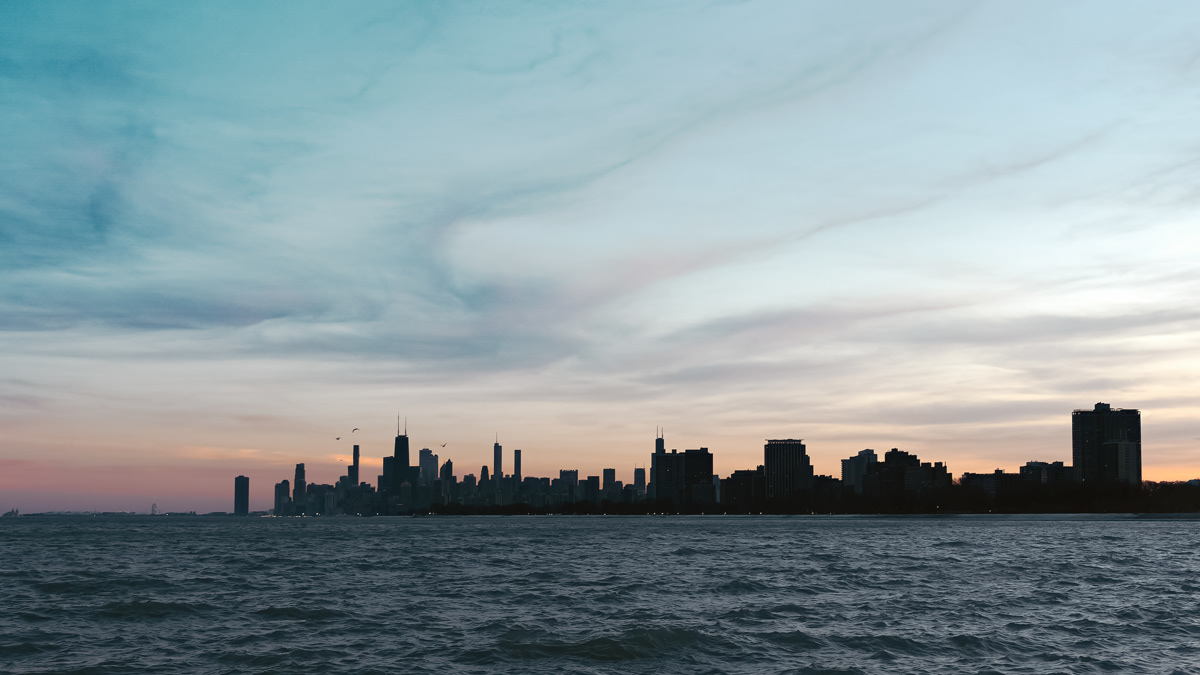 Chicago skyline at sunset overlooking Lake Michigan from Montrose Harbor.