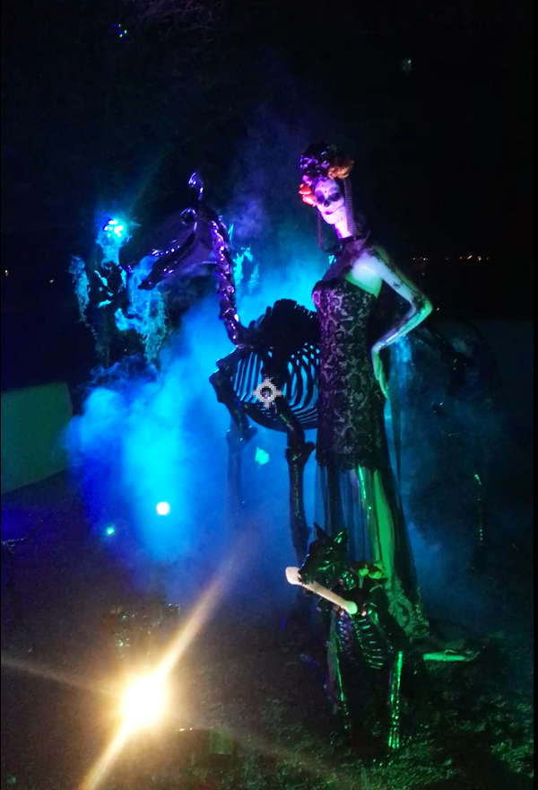 AI-generated Halloween projection mapping on a two-story house featuring ghostly visuals, fog, and Gothic architectural overlays in cinematic blue lighting.