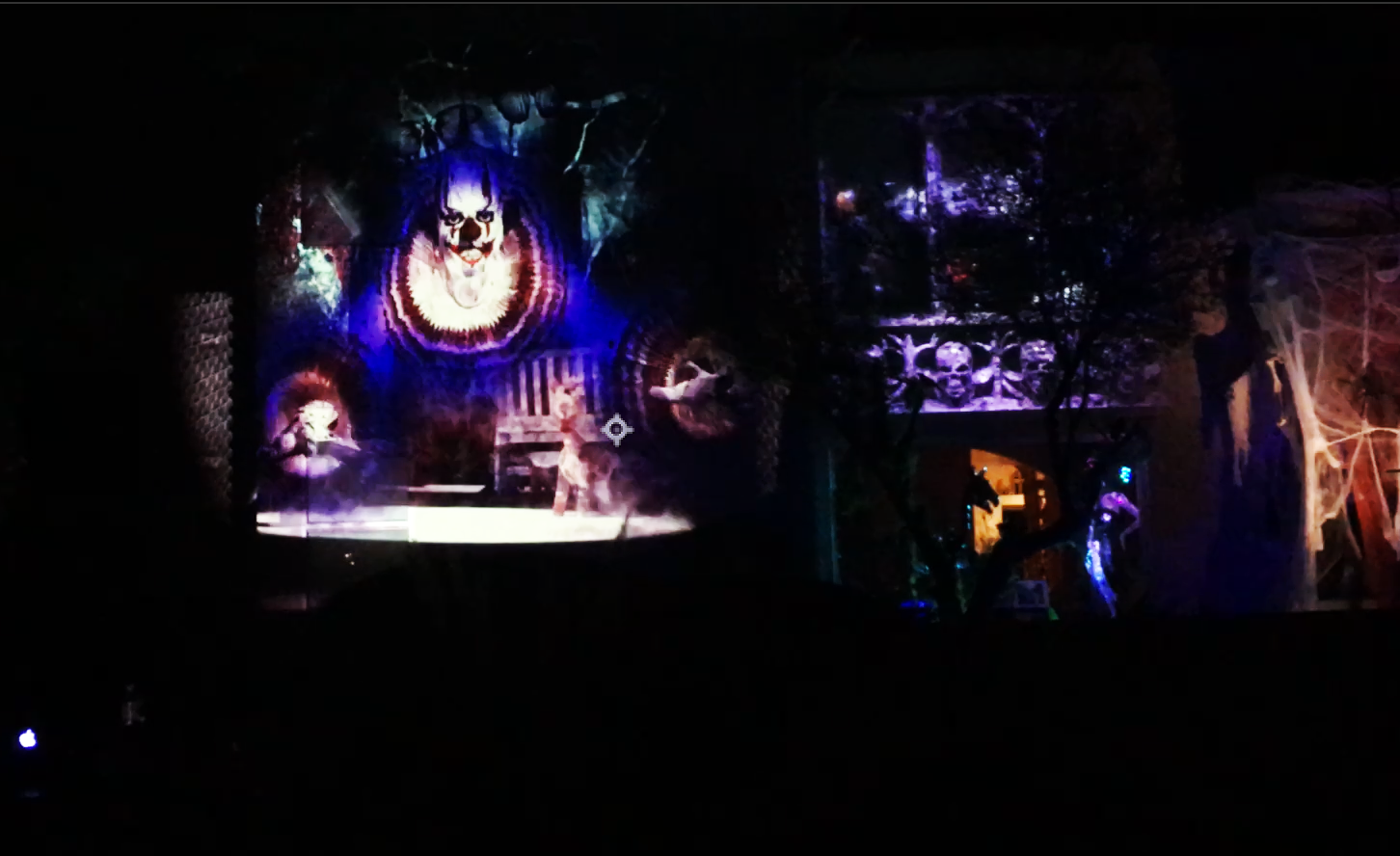 AI-generated Halloween projection mapping on a two-story house featuring ghostly visuals, fog, and Gothic architectural overlays in cinematic blue lighting.