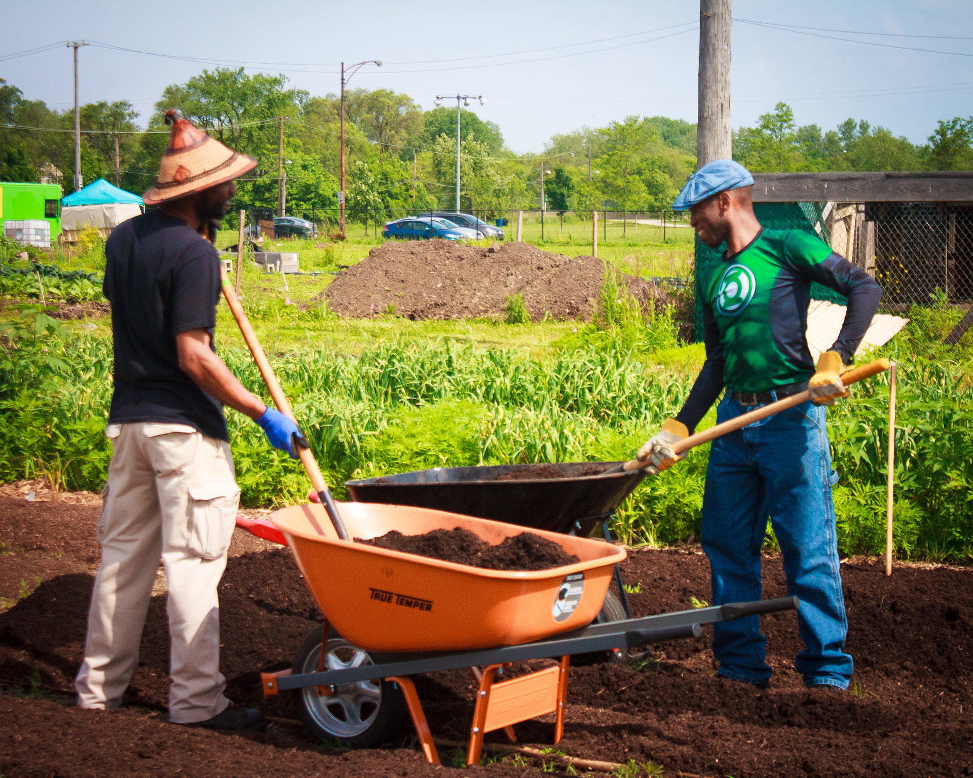 Kamau (husband of Safia) and Fa'sola share a laugh on compost duty during a volunteer day. Chicago, IL ‘19