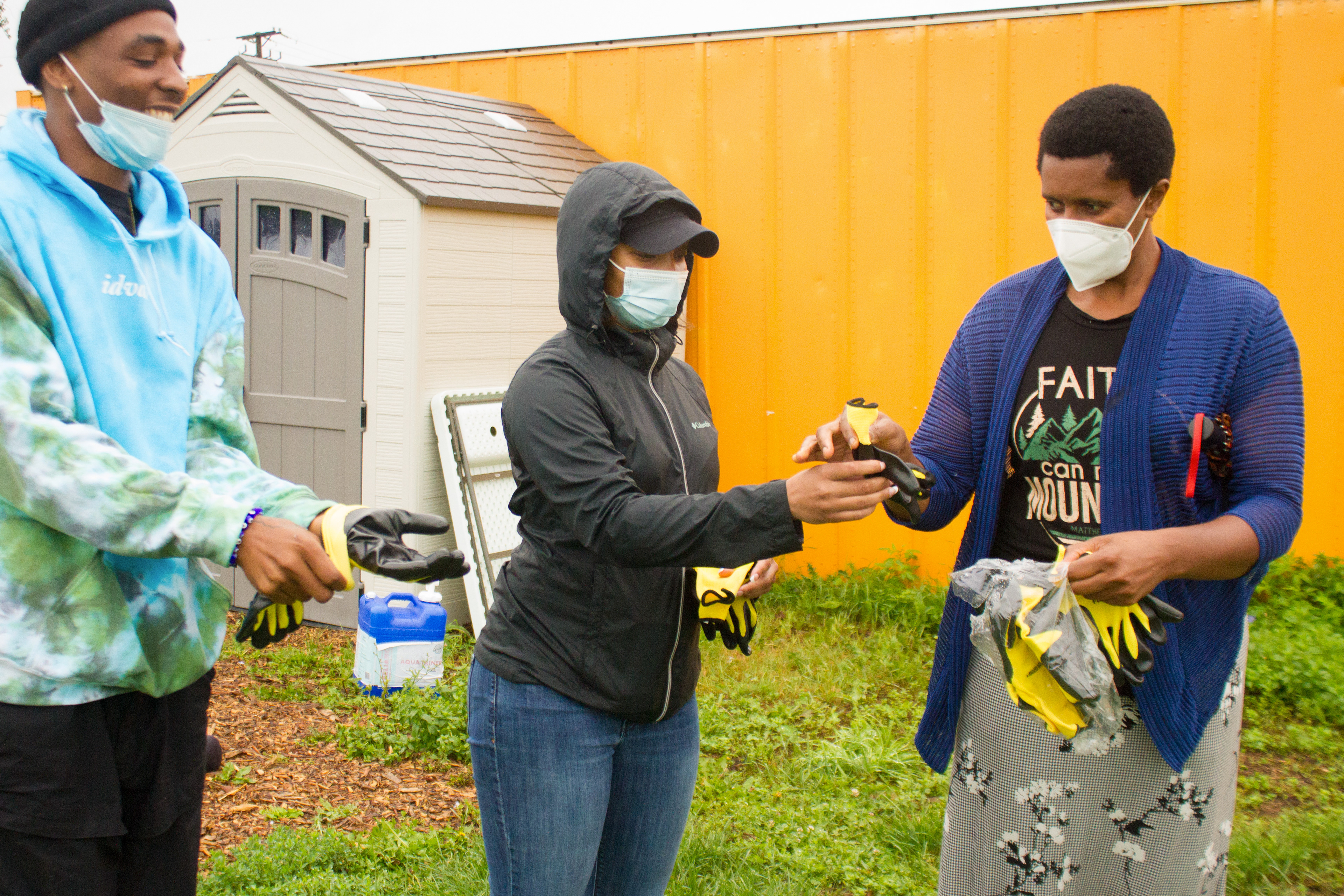 Volunteers assisting each other in suiting up for land stewarding.