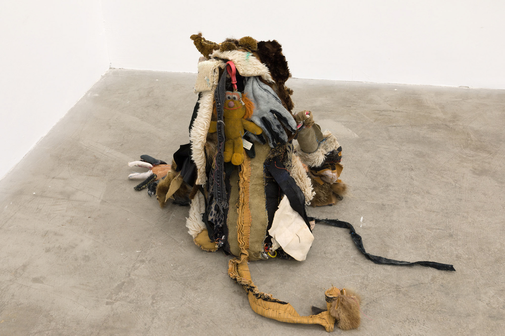 Boom bang (shiny girl). 2018. Hand sewn fabrics, furs and leathers, hand carved plaster, acrylic paint, wire, stones, jute, hardware, human hair, found toy, leather gloves, wood sculpture, chain, dried flowers. 20 x 16 x 20 in (50.8 x 40.6 x 50.8 cm).