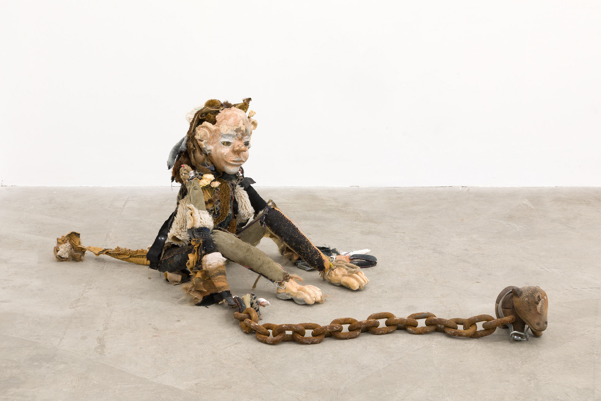 Boom bang (shiny girl). 2018. Hand sewn fabrics, furs and leathers, hand carved plaster, acrylic paint, wire, stones, jute, hardware, human hair, found toy, leather gloves, wood sculpture, chain, dried flowers. 20 x 16 x 20 in (50.8 x 40.6 x 50.8 cm).
