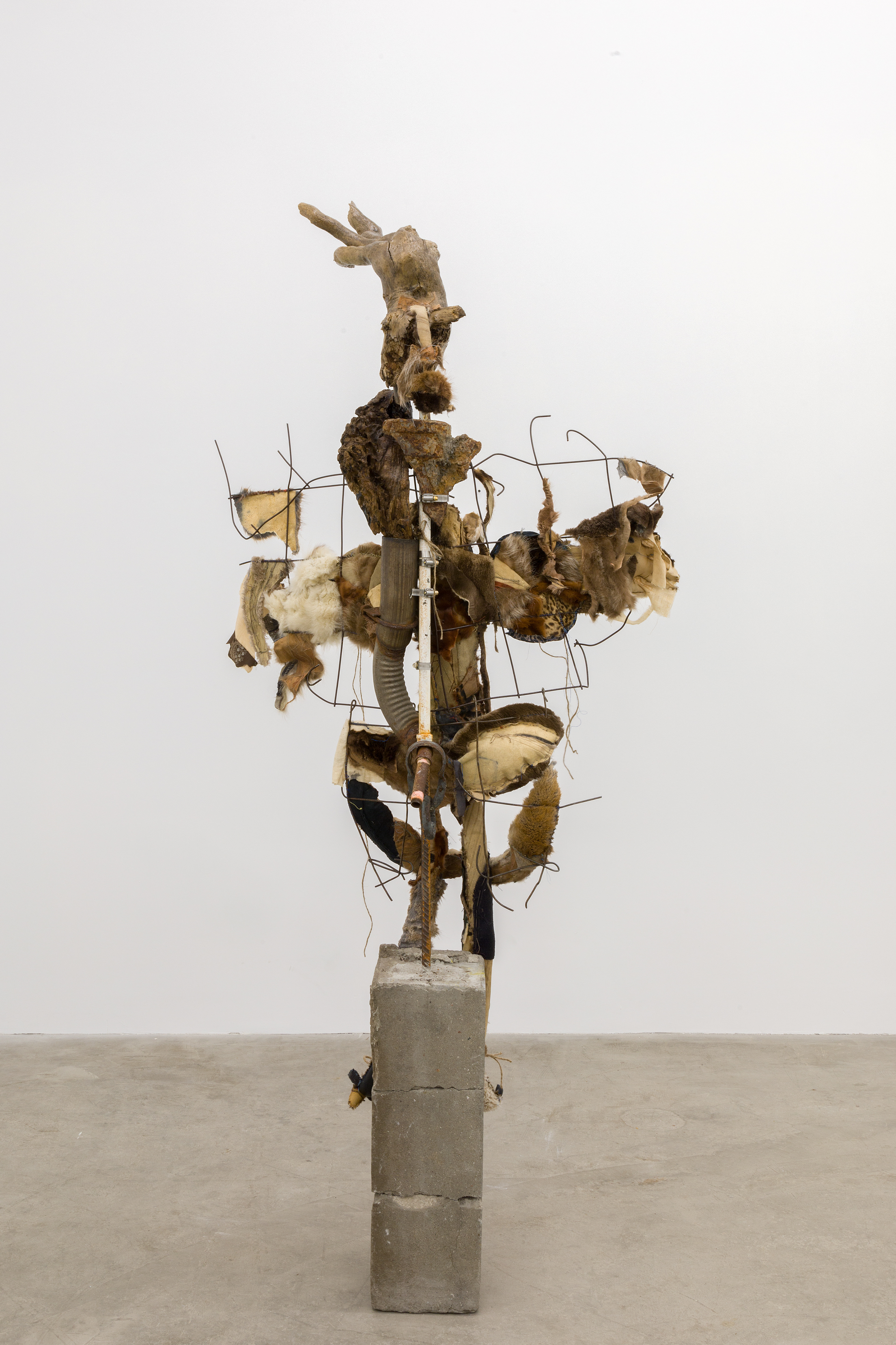 Three angels waiting, 2018. Concrete, rebar, concrete mesh, hand sewn furs, leathers and fabrics, cotton batting, stones, pipes, driftwood, dried flowers, hardware. 76 x 38 x 24 inches (193.04 x 96.52 x 60.96 cm).