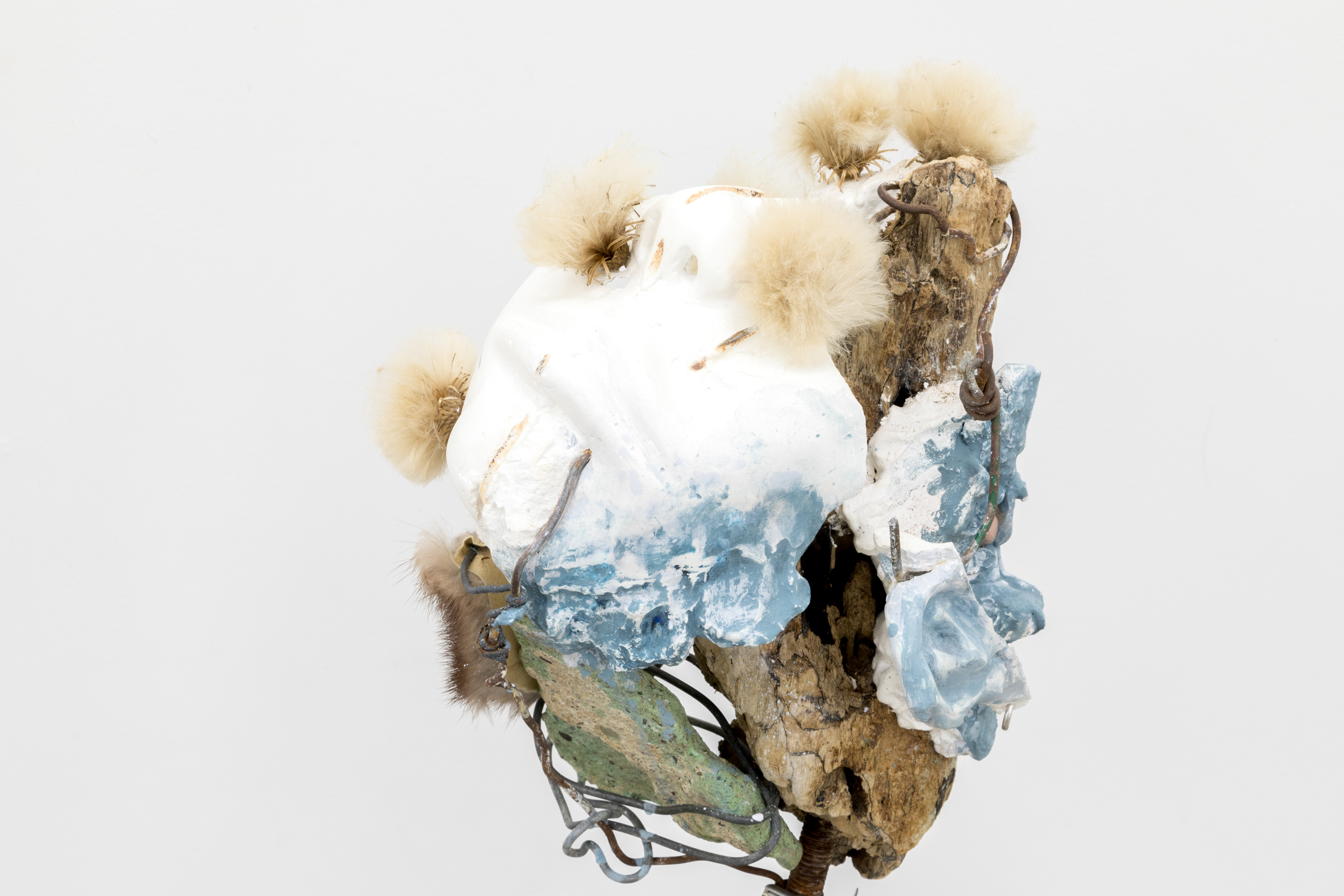 Big tooth (angels in a sleepy current), 2017. Hand carved plaster, stones, wire, acrylic paint, fur, milk thistle seeds, earring, driftwood, rebar, chain, concrete.