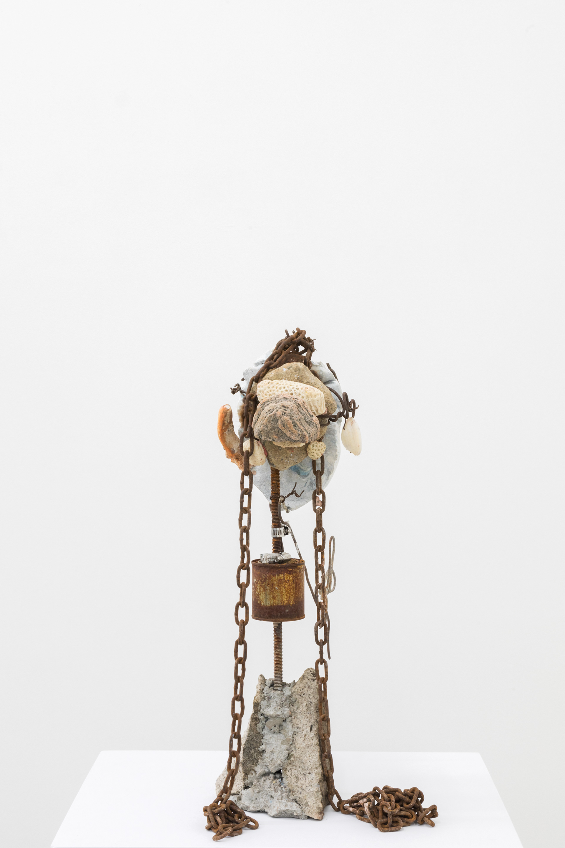 Seashell (grinner), 2017. Hand carved plaster, wire, acrylic paint, stones, Net %: reef stones, fur, chain, paint can, rebar, concrete, earring, seashell 25.5 x 13 x 16 inches (64.77 x 33.02 x 40.64 cm)
