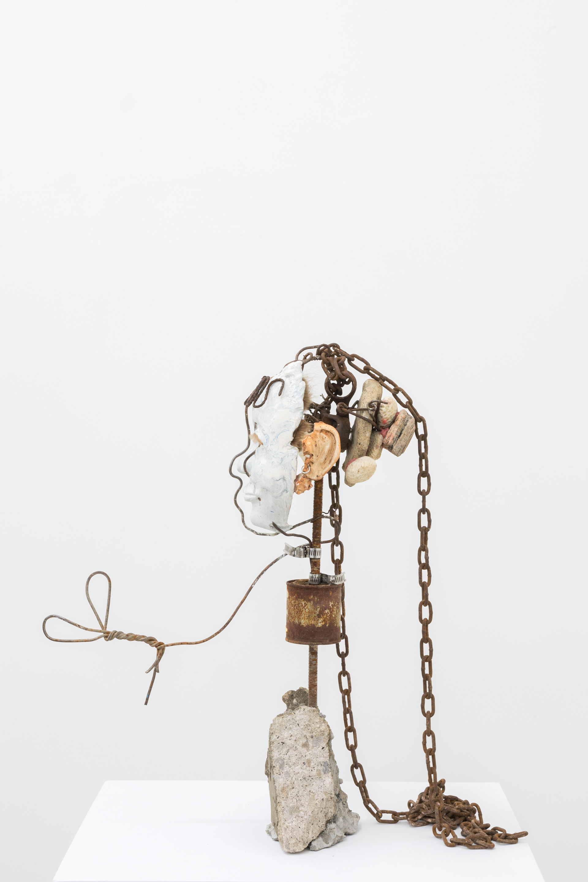 Seashell (grinner), 2017. Hand carved plaster, wire, acrylic paint, stones, Net %: reef stones, fur, chain, paint can, rebar, concrete, earring, seashell 25.5 x 13 x 16 inches (64.77 x 33.02 x 40.64 cm)