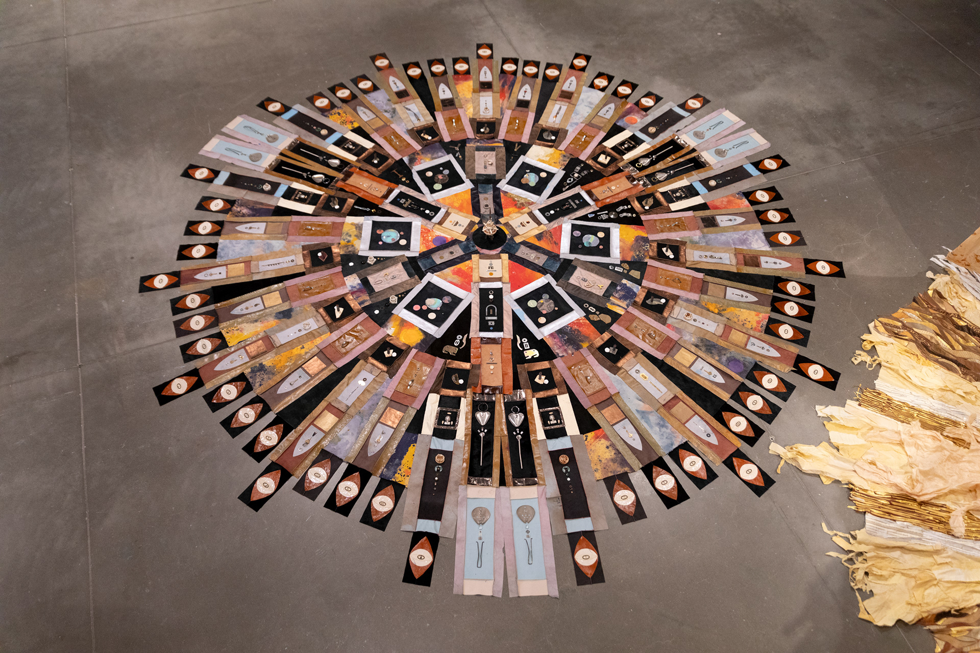 The Last Transmission, 2024, Repurposed leather and suede; cotton canvas; acrylic paint and finisher; leather, fabric, and natural dyes; assorted found metal, wood, ceramic, and glass objects; wire; beads; seashells; coated nylon thread; and coated cotton thread, 8H x 182 inch diameter