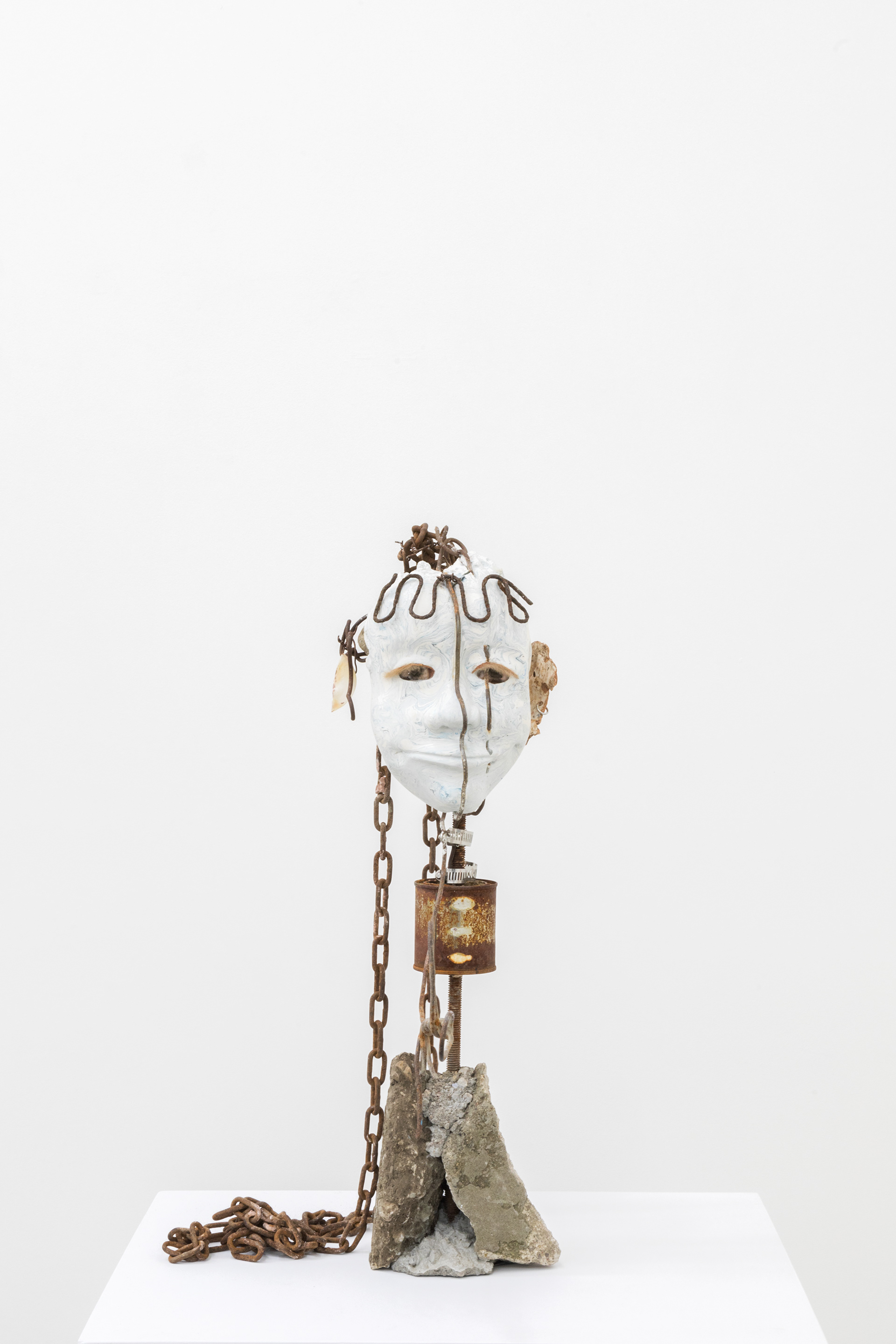 Seashell (grinner), 2017. Hand carved plaster, wire, acrylic paint, stones, Net %: reef stones, fur, chain, paint can, rebar, concrete, earring, seashell 25.5 x 13 x 16 inches (64.77 x 33.02 x 40.64 cm)