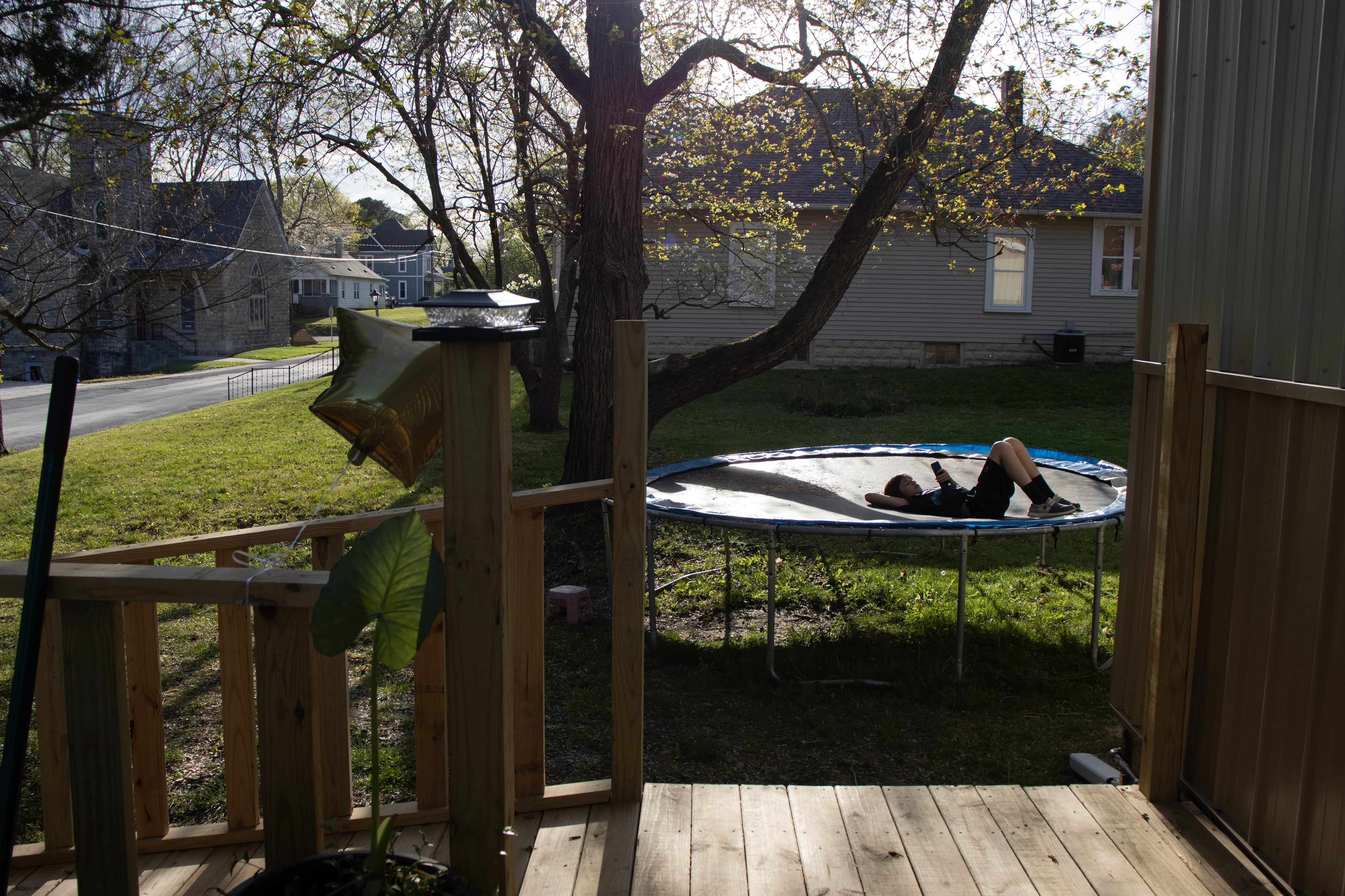 11-year-old Mark Pitts lays on the trampoline looking at his phone during his 12th birthday party in Cobden, Ill. on Saturday evening, April 13, 2024.