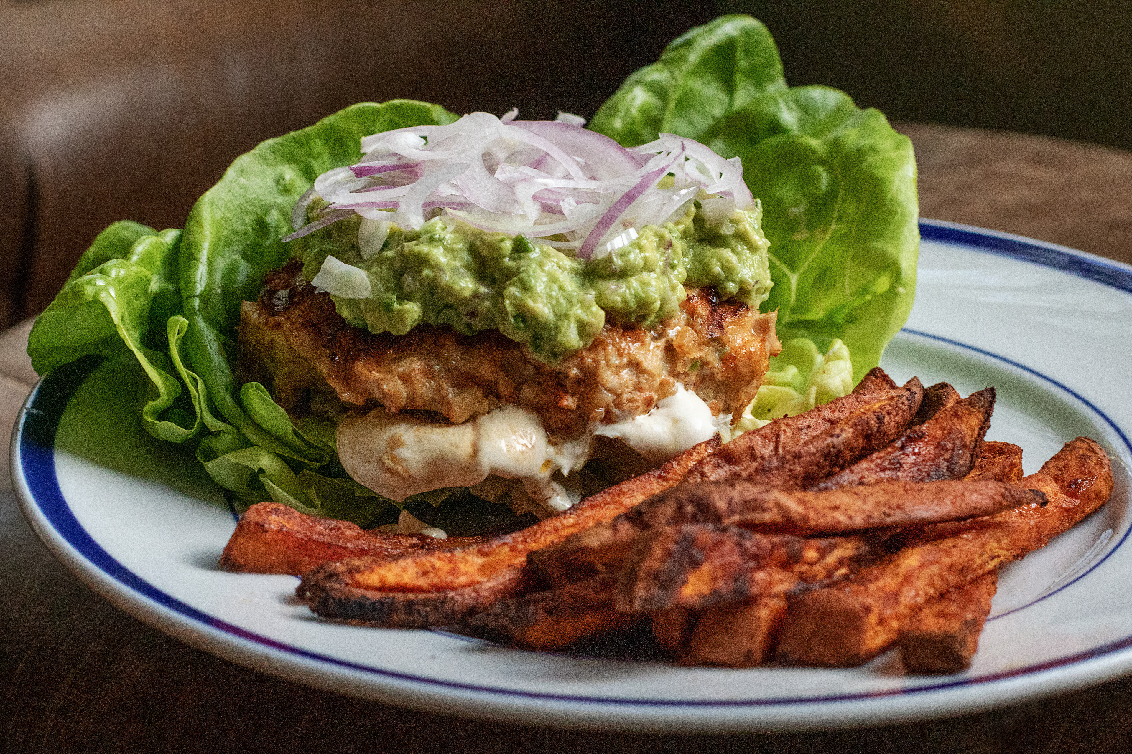 bunless cheese-belly chicken burger with homemade guacamole and baked sweet potato fries