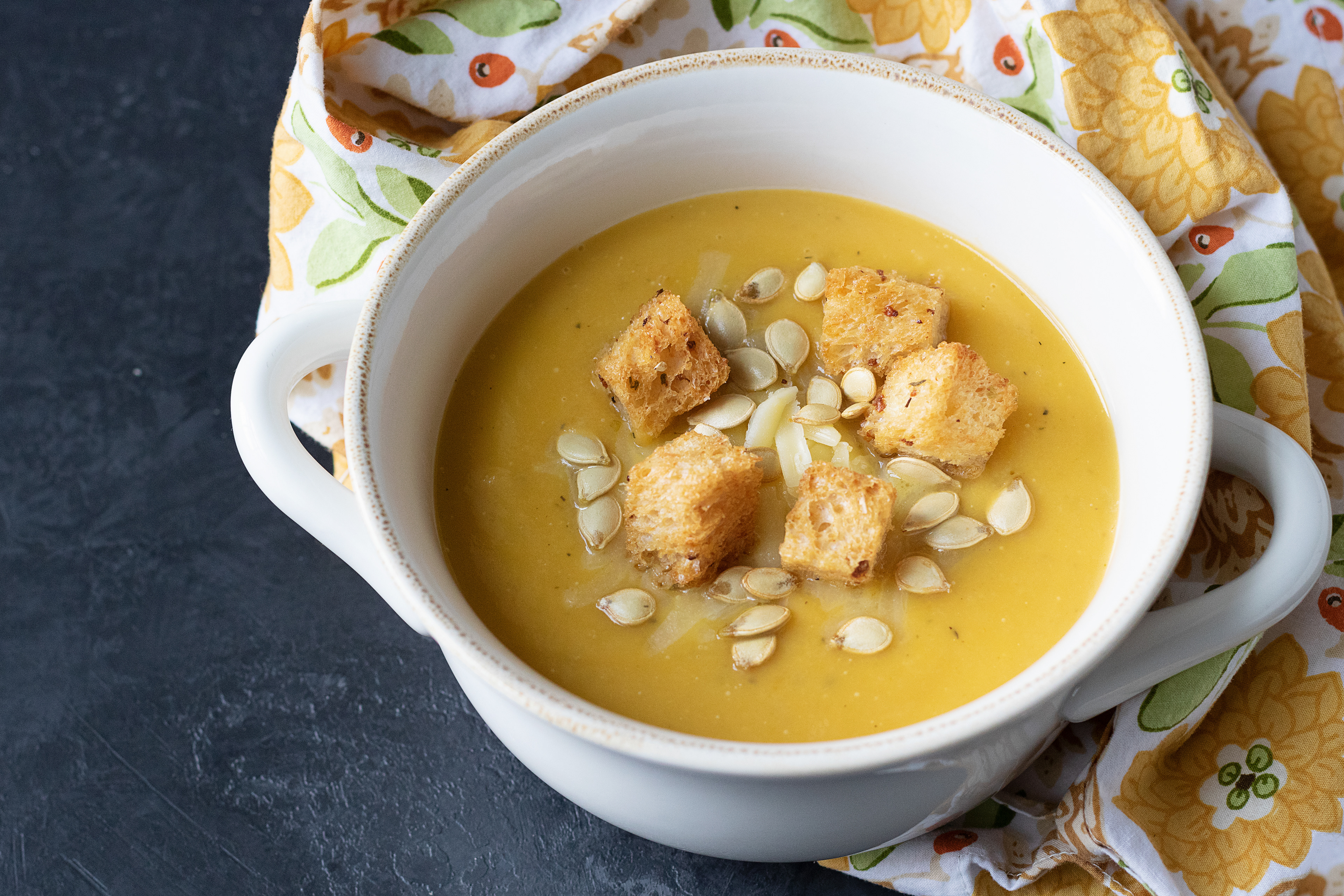 butternut pear bisque topped with aged cheese, roasted squash seeds, and garlic croutons
