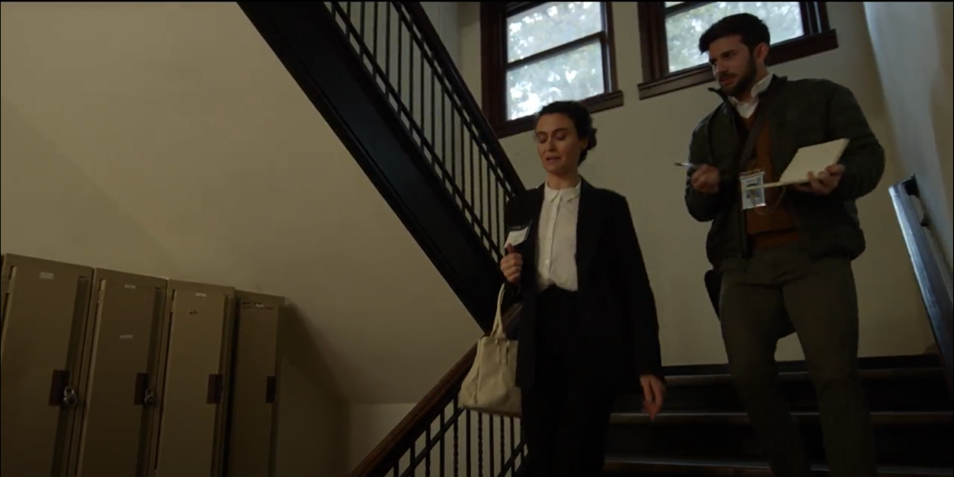Dr. Amy & journalist Carter descend staircase to the underground facility