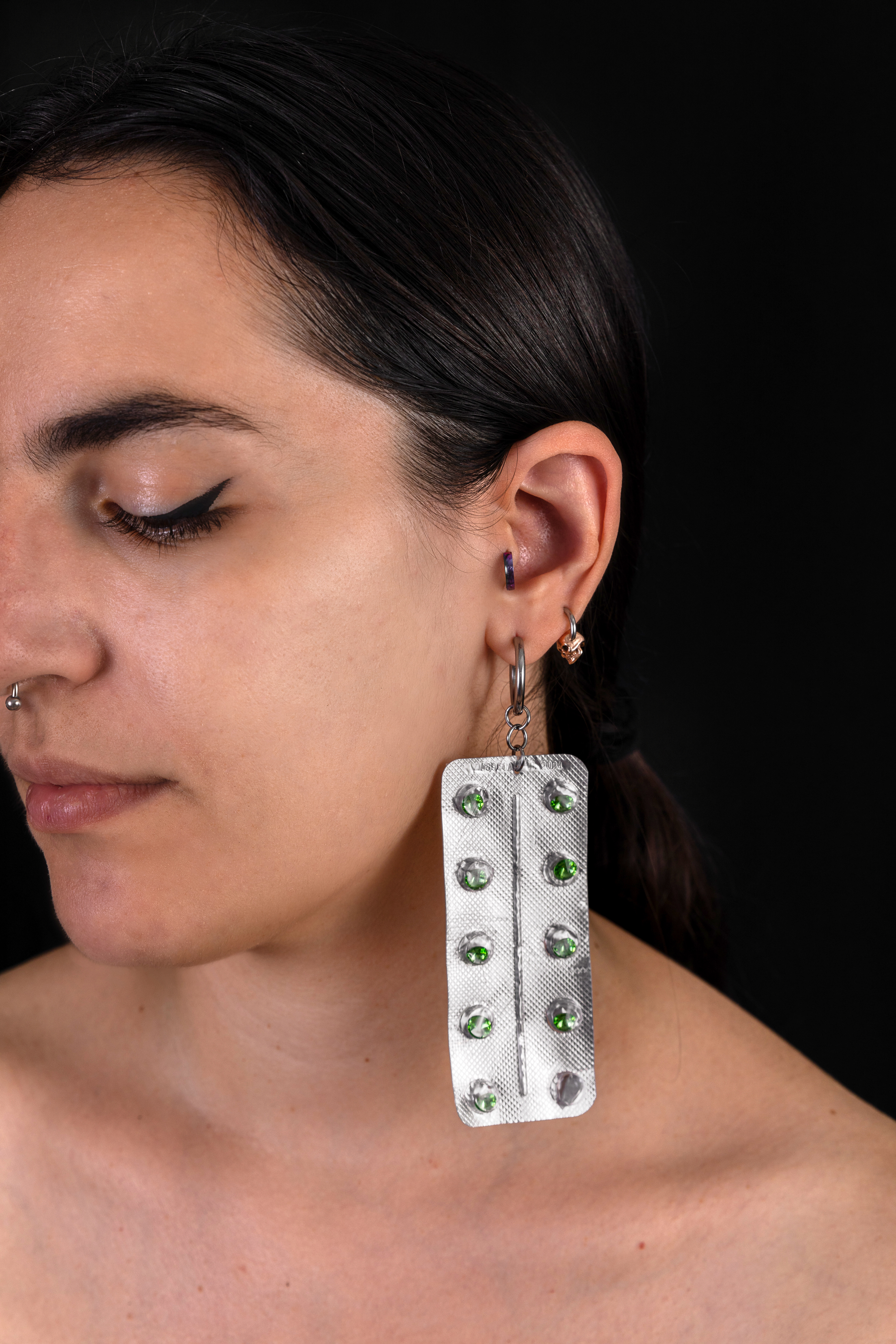 Conceptual earring titled "Did you forget to take your meds?" close up