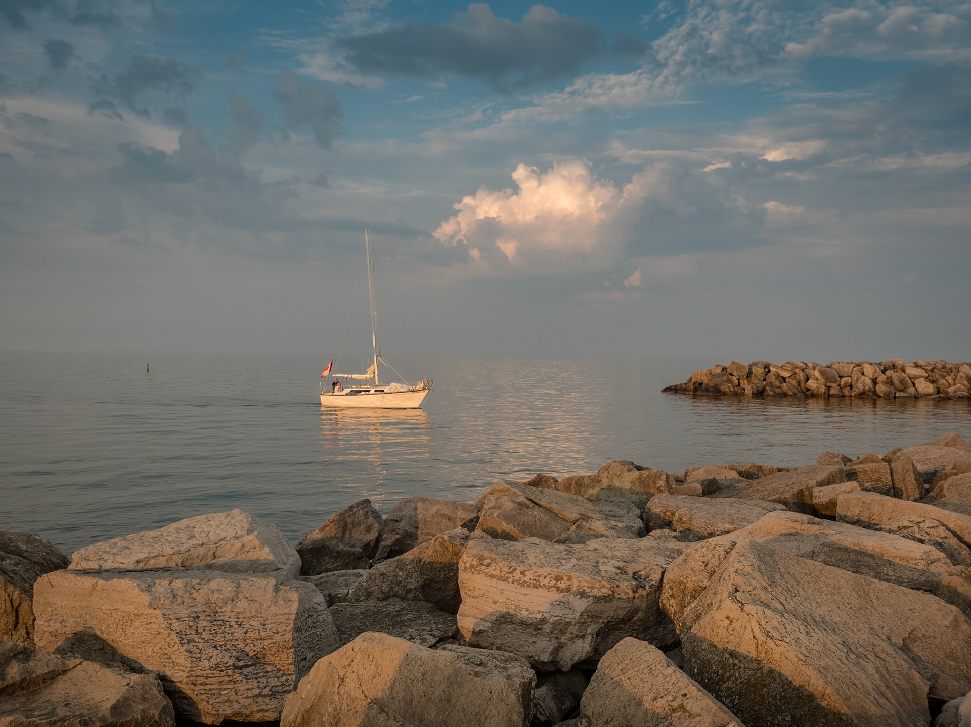 A sailboat returns to the harbour in Thornbury as dusk falls on Georgian Bay.